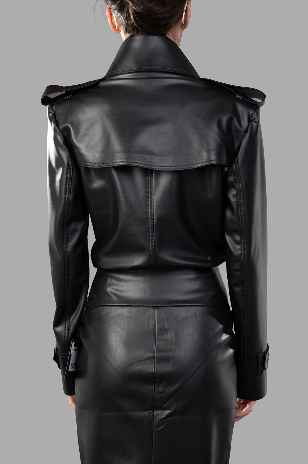 Norma Kamali Double-breasted Trench Bodysuit featuring a sleek black PU leather back view with elegant collar detail.