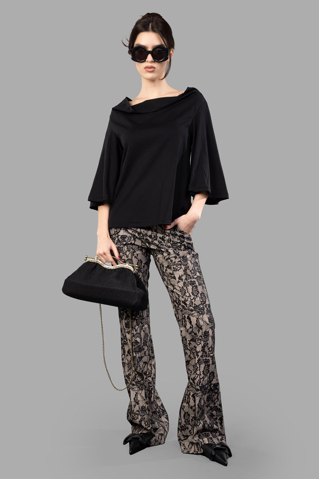 Joseph Patchwork Lace Trousers in black, featuring a deconstructed pattern, shown on-model with a black top and bag.