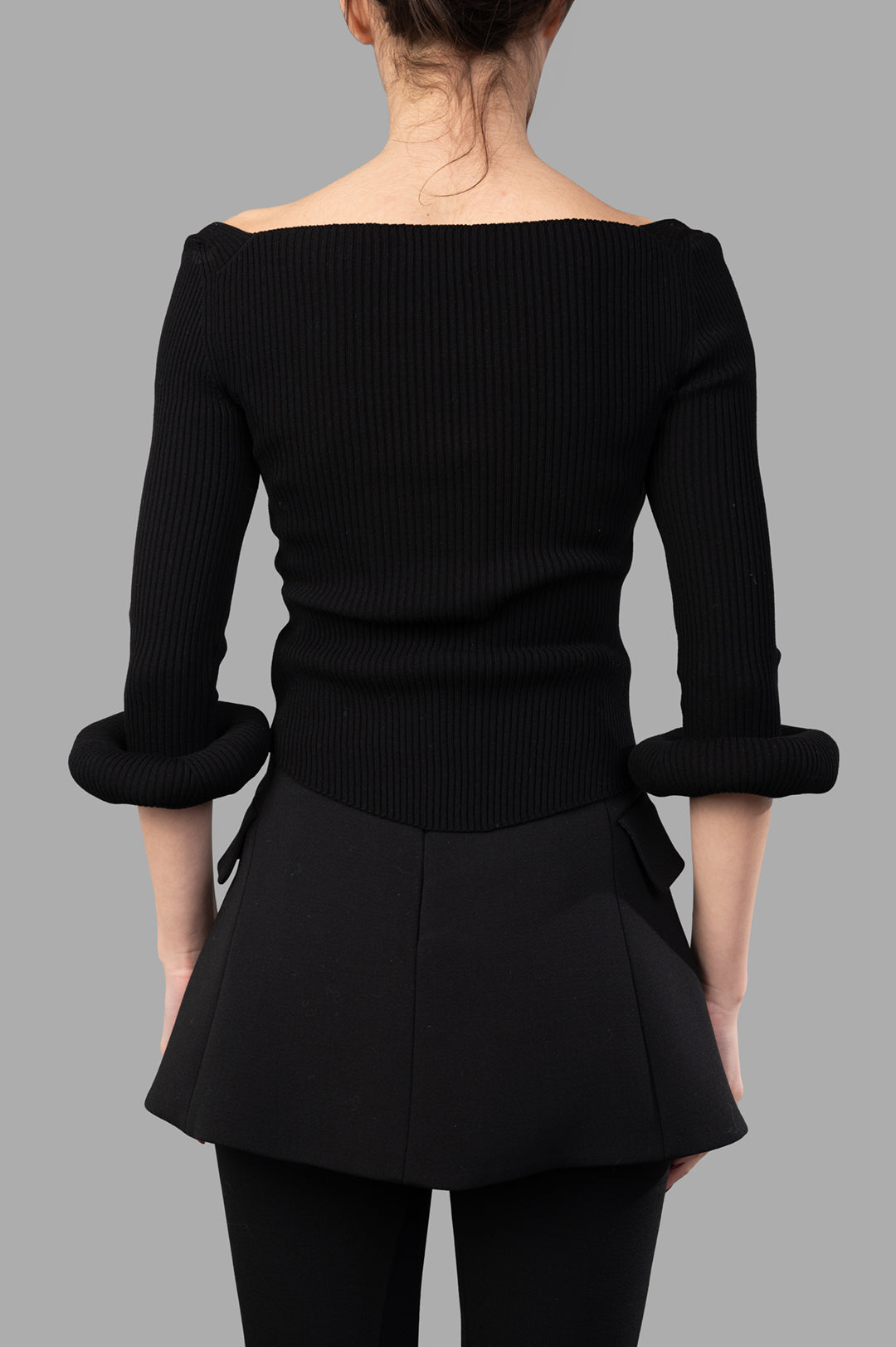 A.W.A.K.E. MODE Knit Top With Donut Sleeves, showcasing the back view with ribbed texture and unique donut cuffs in black.