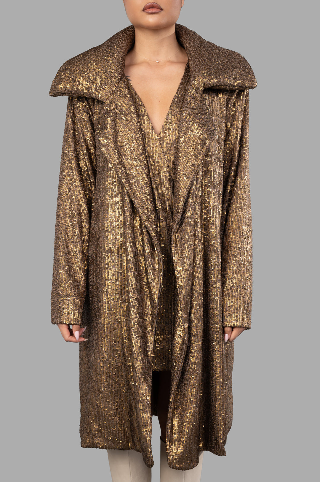 Norma Kamali Sequin Trench features a dazzling bronze design with oversized lapels and a luxurious all-over sequin texture.
