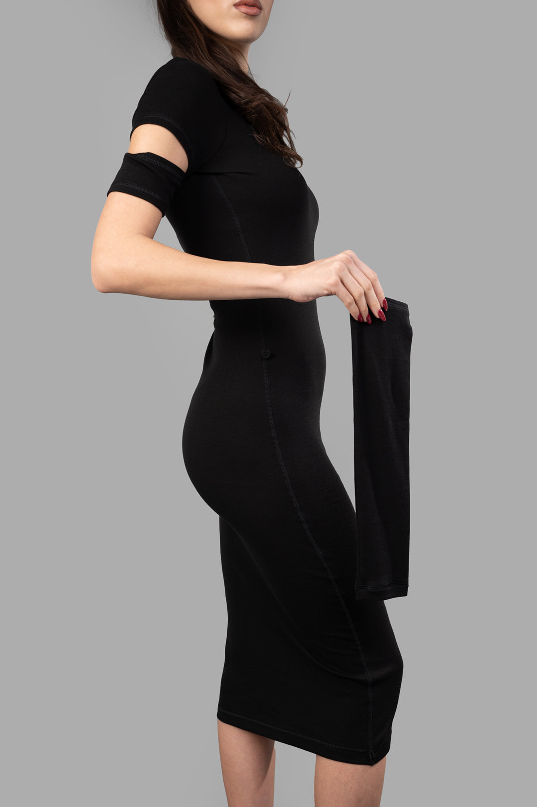 Helmut Lang Slash Mini Dress in black, showcasing cut-out detailing and detachable sleeves, modeled from the side.
