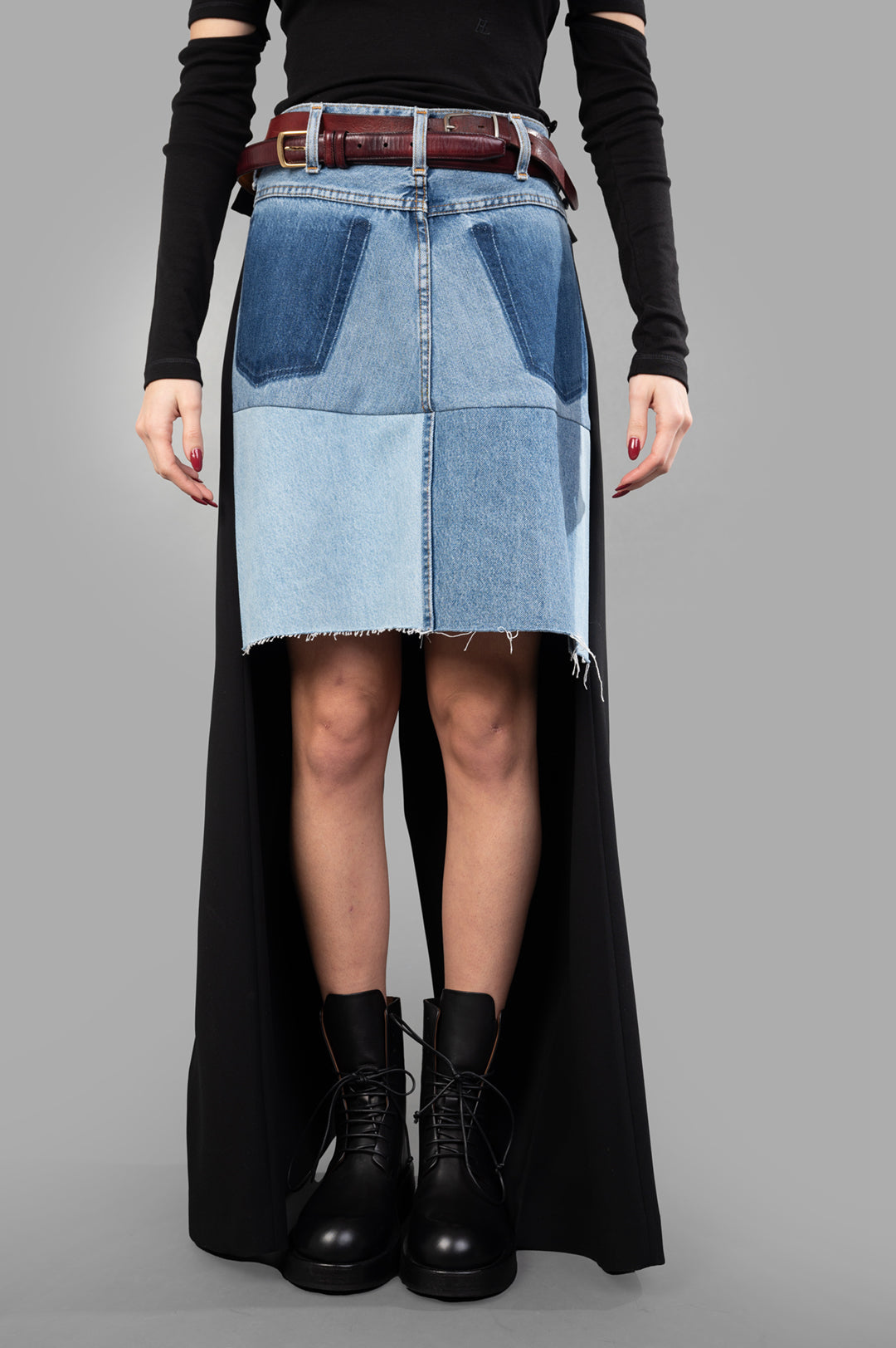 A.W.A.K.E. MODE Asymmetric Half-Denim Skirt shown on model, featuring a unique two-tone design and frayed hem detail.