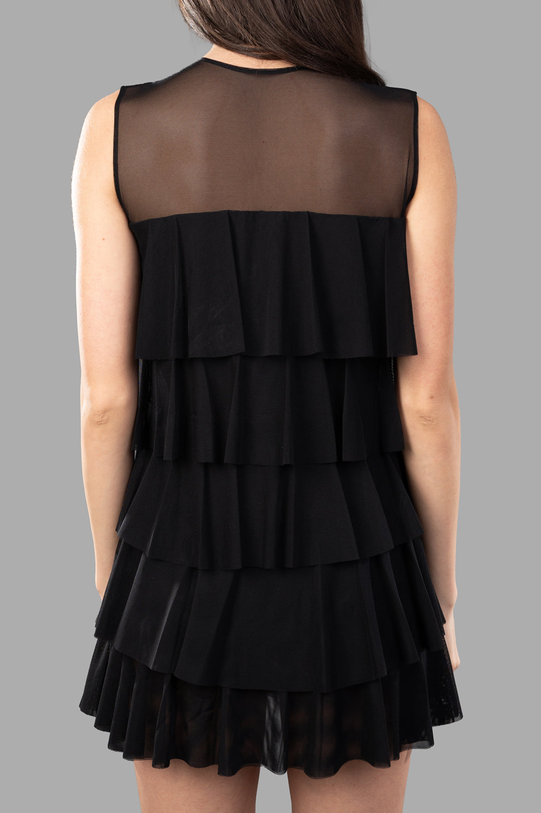 Norma Kamali Sleeveless Ruffle Dress showcases a stylish back view with tiered ruffles and a sheer top. Color: Black.