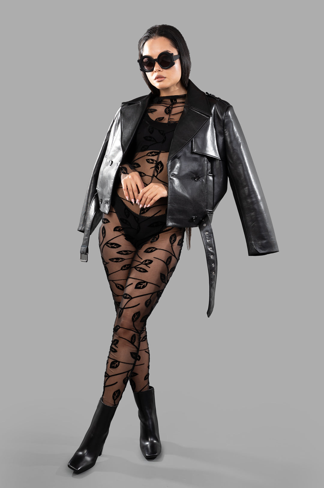 Norma Kamali Long-sleeved Lace Catsuit, high-neck, slim fit, black lace detail, on-model, paired with leather jacket.