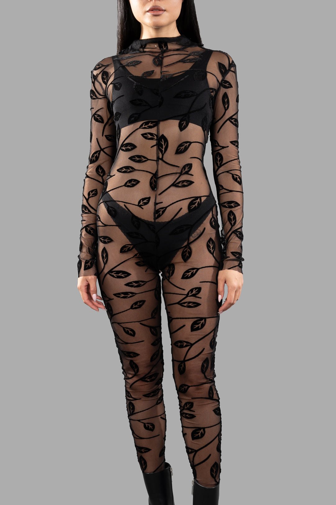 Norma Kamali Long-sleeved Lace Catsuit featuring floral lace design, high-neck, and slim fit, presented on model, black.