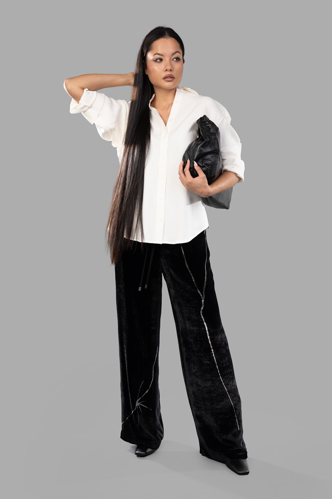 Anine Bing Braxton Shirt shown front view on model, paired with black pants and clutch.