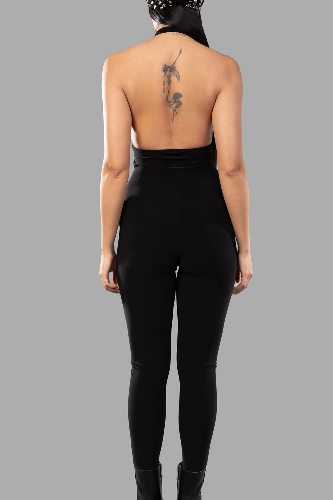 Norma Kamali Halter Shirred Catsuit viewed from the back, showcasing a sleek fit and chic halter design in black.