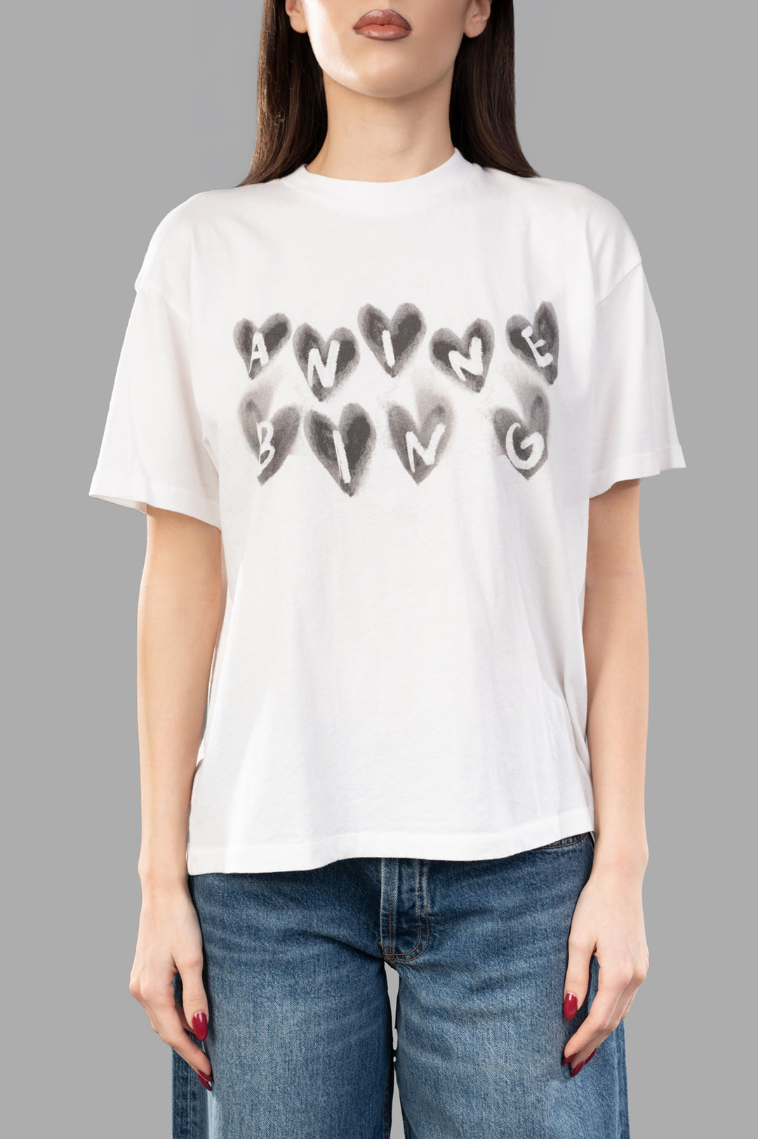 Anine Bing Spencer Hearts T-shirt displayed on a model, featuring a relaxed fit and heart logo in soft gray on white cotton.