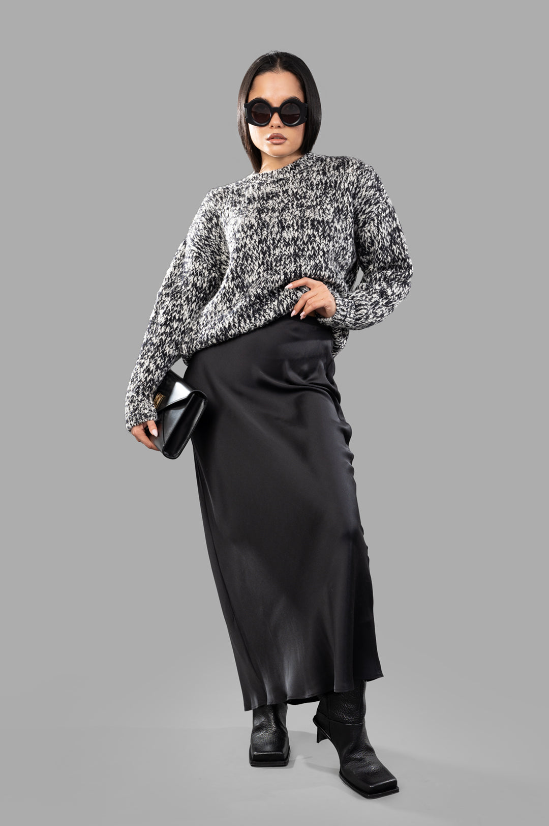 Anine Bing Melange Sweater modeled, black/white, crew neck, long sleeves, styled with black skirt and boots.