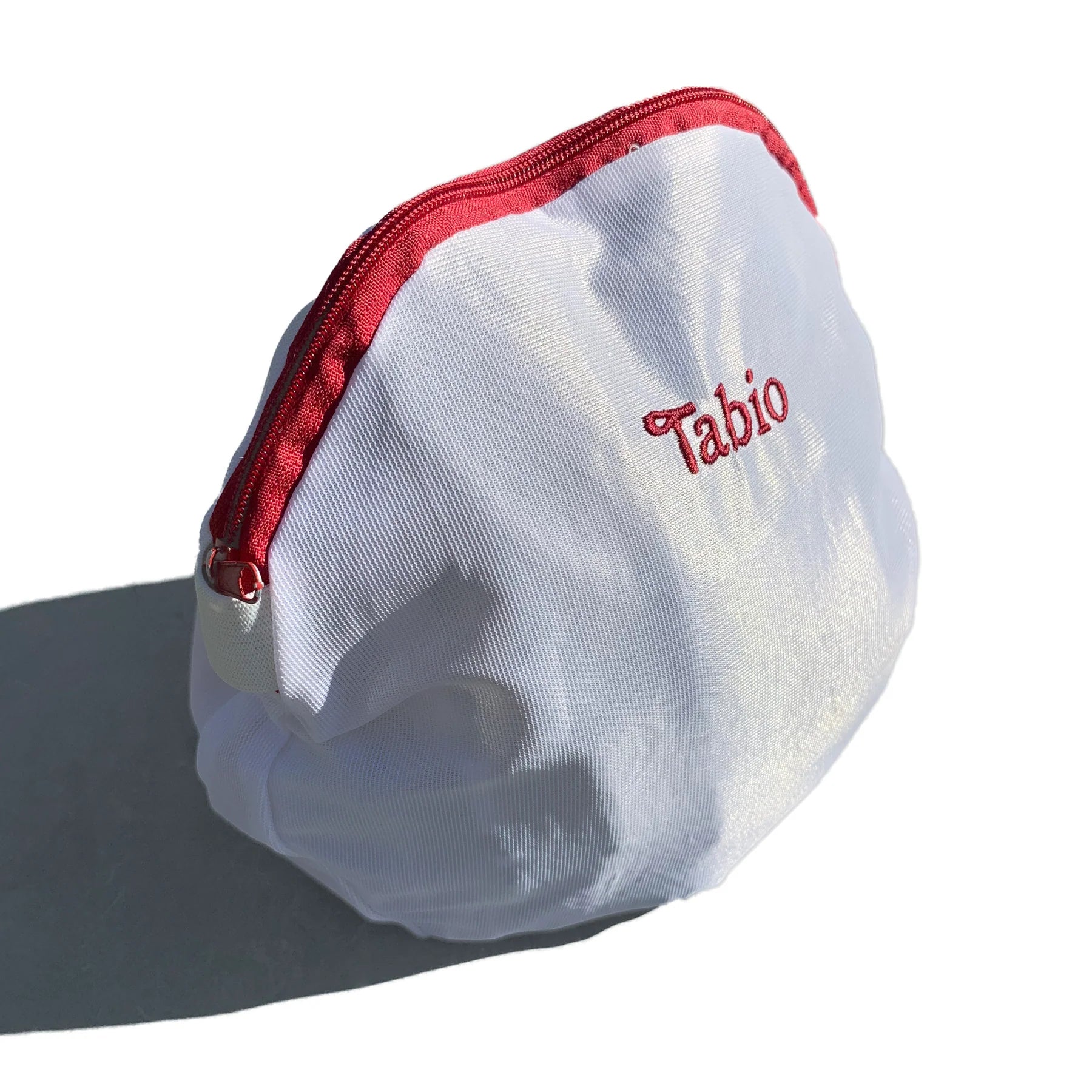Tabio. Sock Washing Net in white, showcasing its zipper and delicate fabric, ideal for protecting socks during laundry.