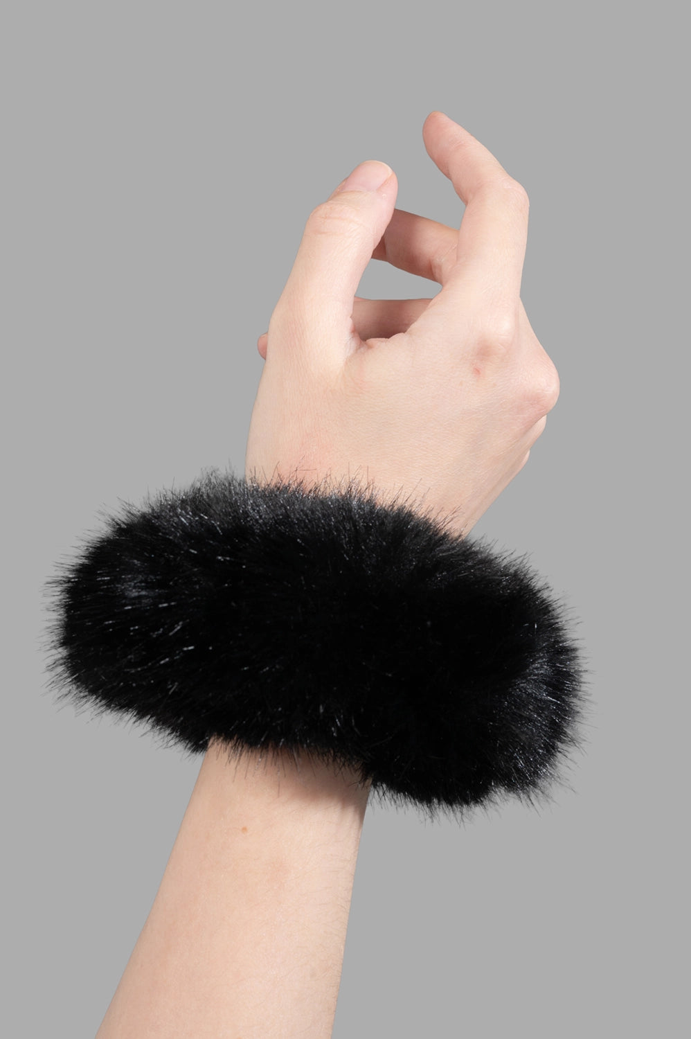 Close-up of tan faux-fur cuff showing dense pile, circular shape, and soft texture - black