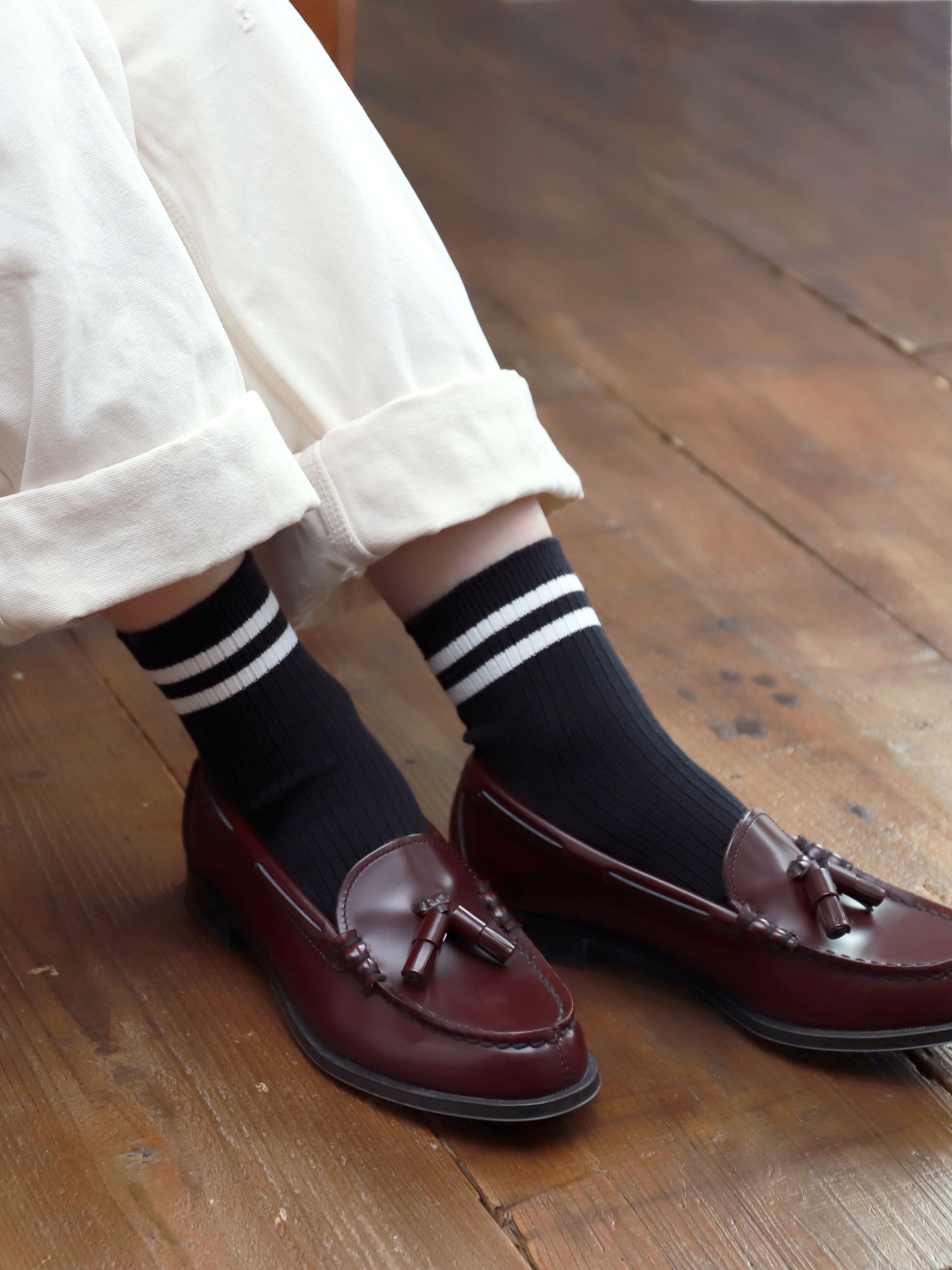 Tabio Neat Tennis Rib Ankle Socks in black shown worn with loafers, featuring ribbed texture and striped bands for sporty.