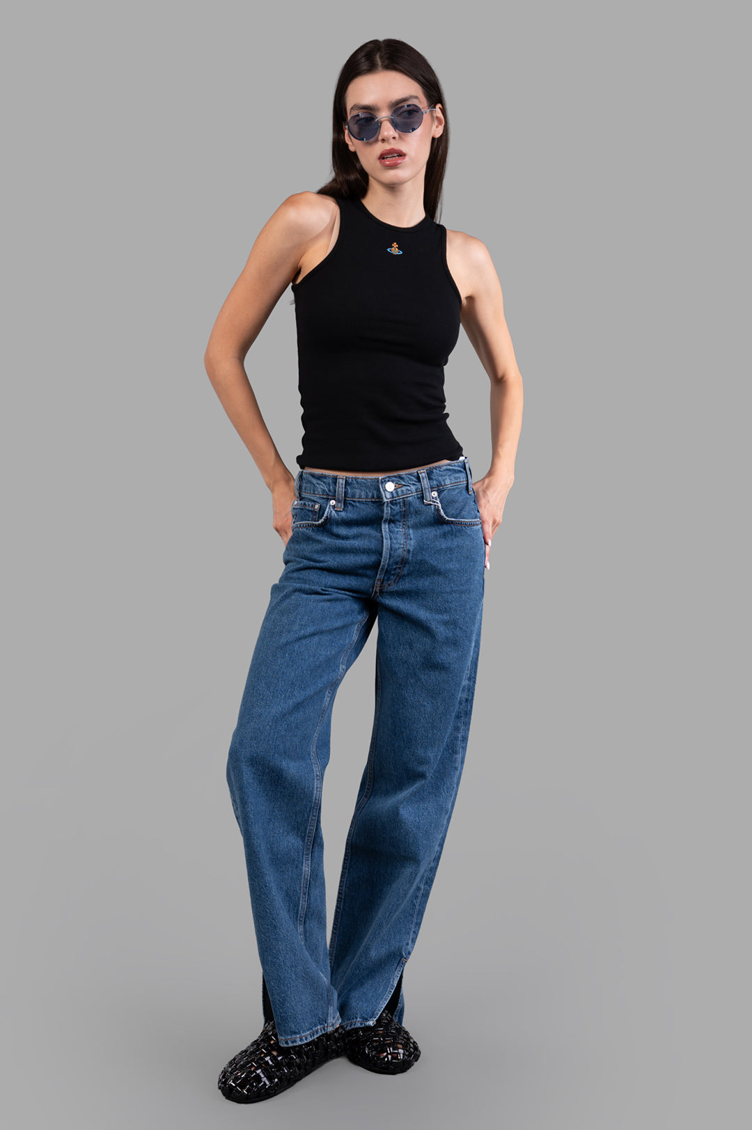 Vivienne Westwood 90s Vest in Black, front view on model; ribbed tank with high neck, small chest logo, styled with jeans