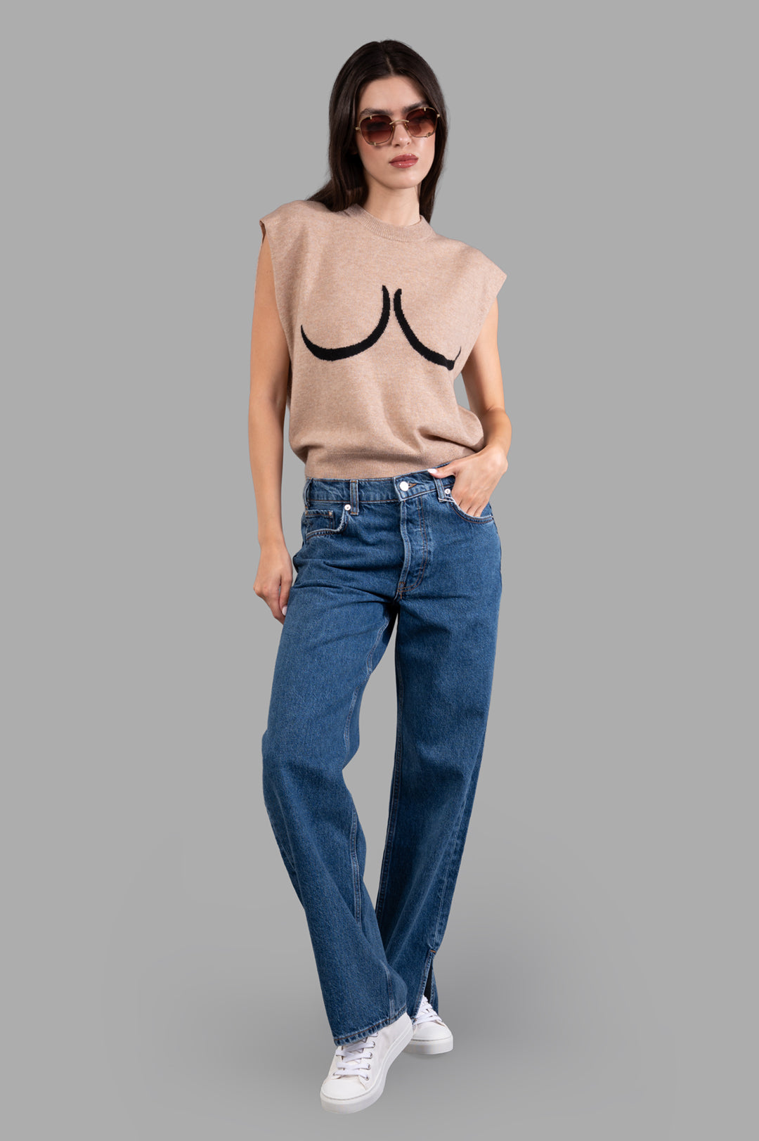Anine Bing Roy Jeans in blue on-model front view, midweight cotton, relaxed fit, paired with sneakers and a sleeveless top.