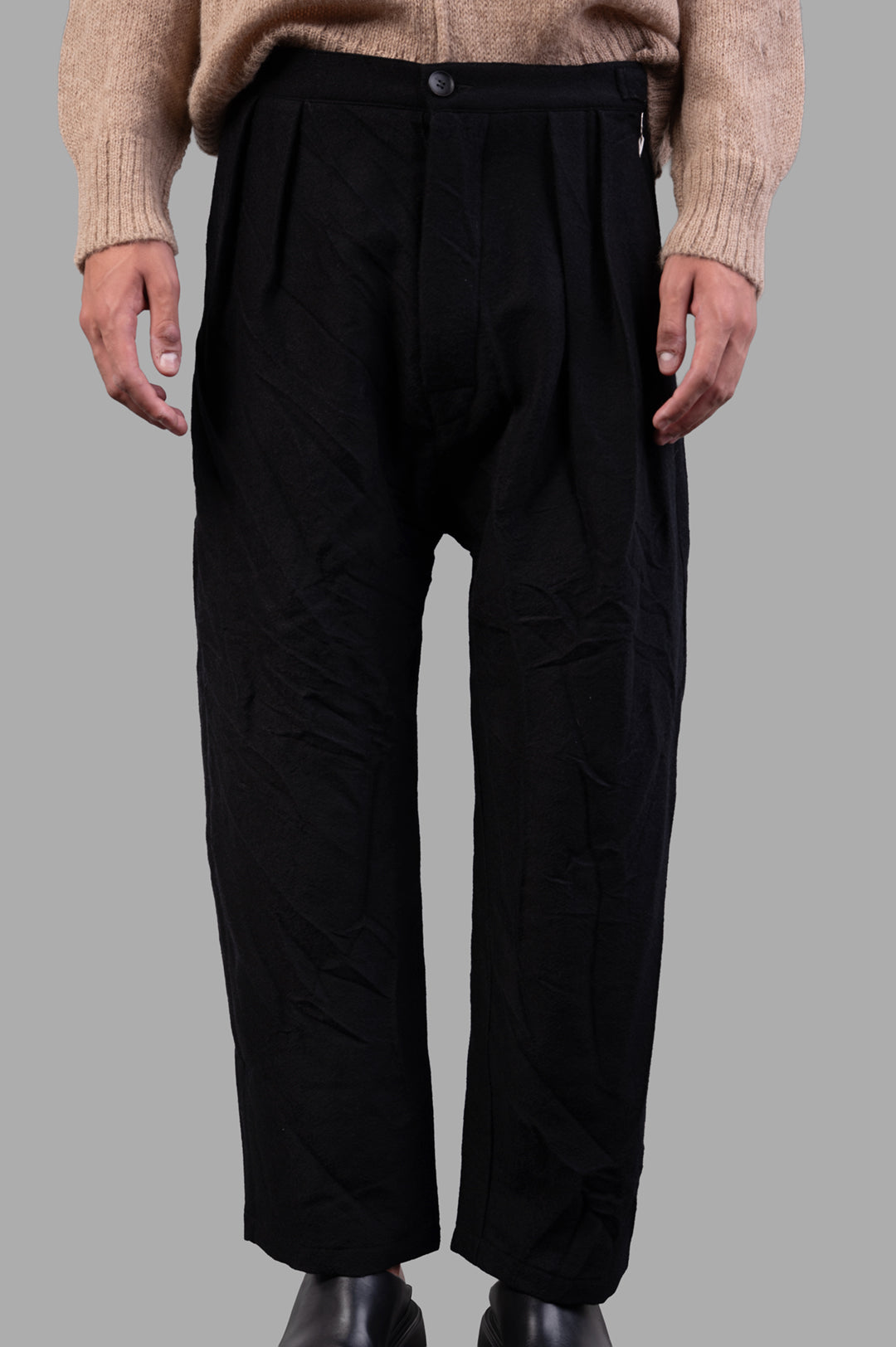 Marc Point Wool Trousers with front pleats, high waist, cropped length, styled on model, black 100% wool fabric.