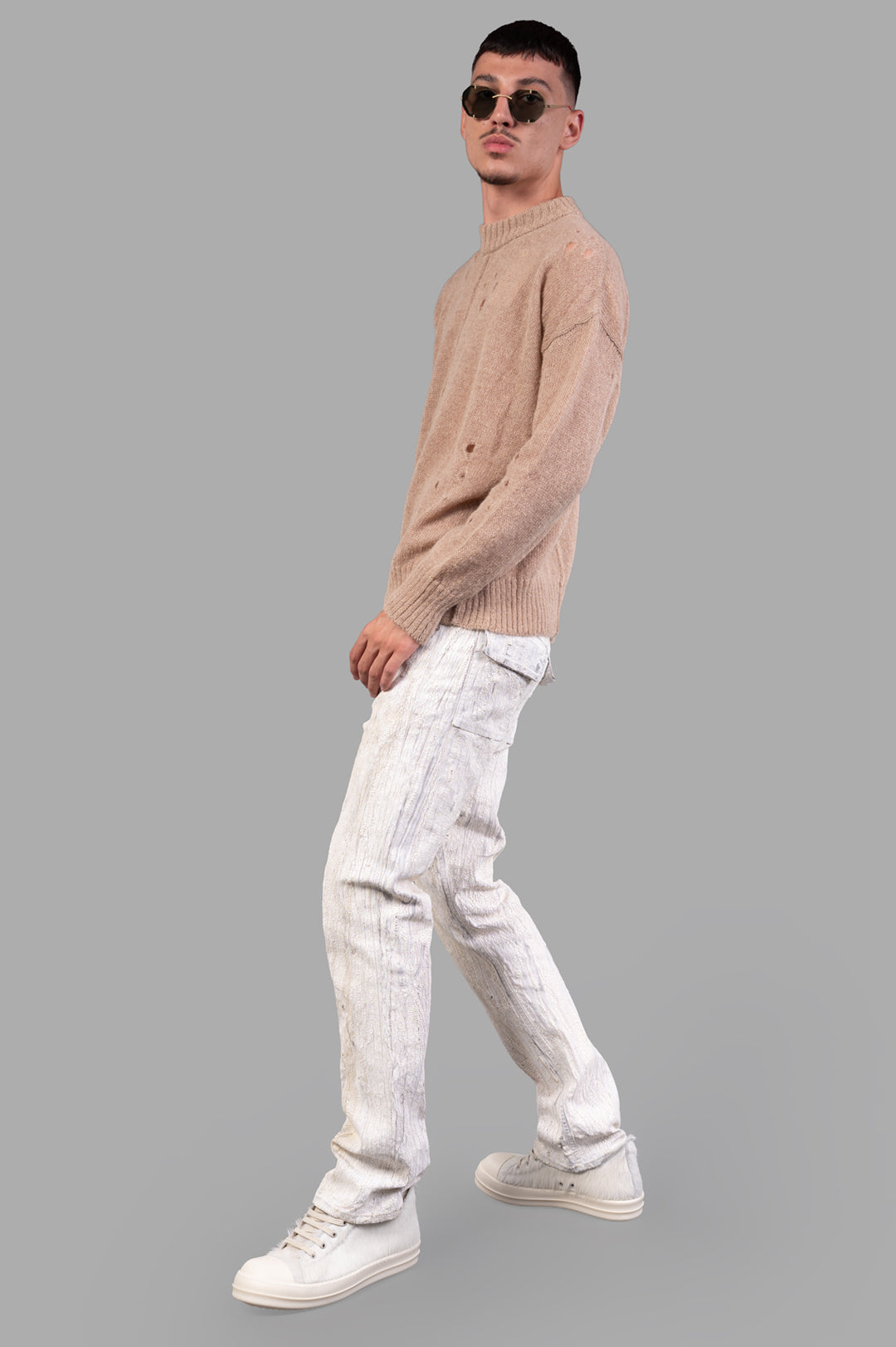 Marc Point Beige Sweater on-model side view, paired with white textured pants and sneakers.