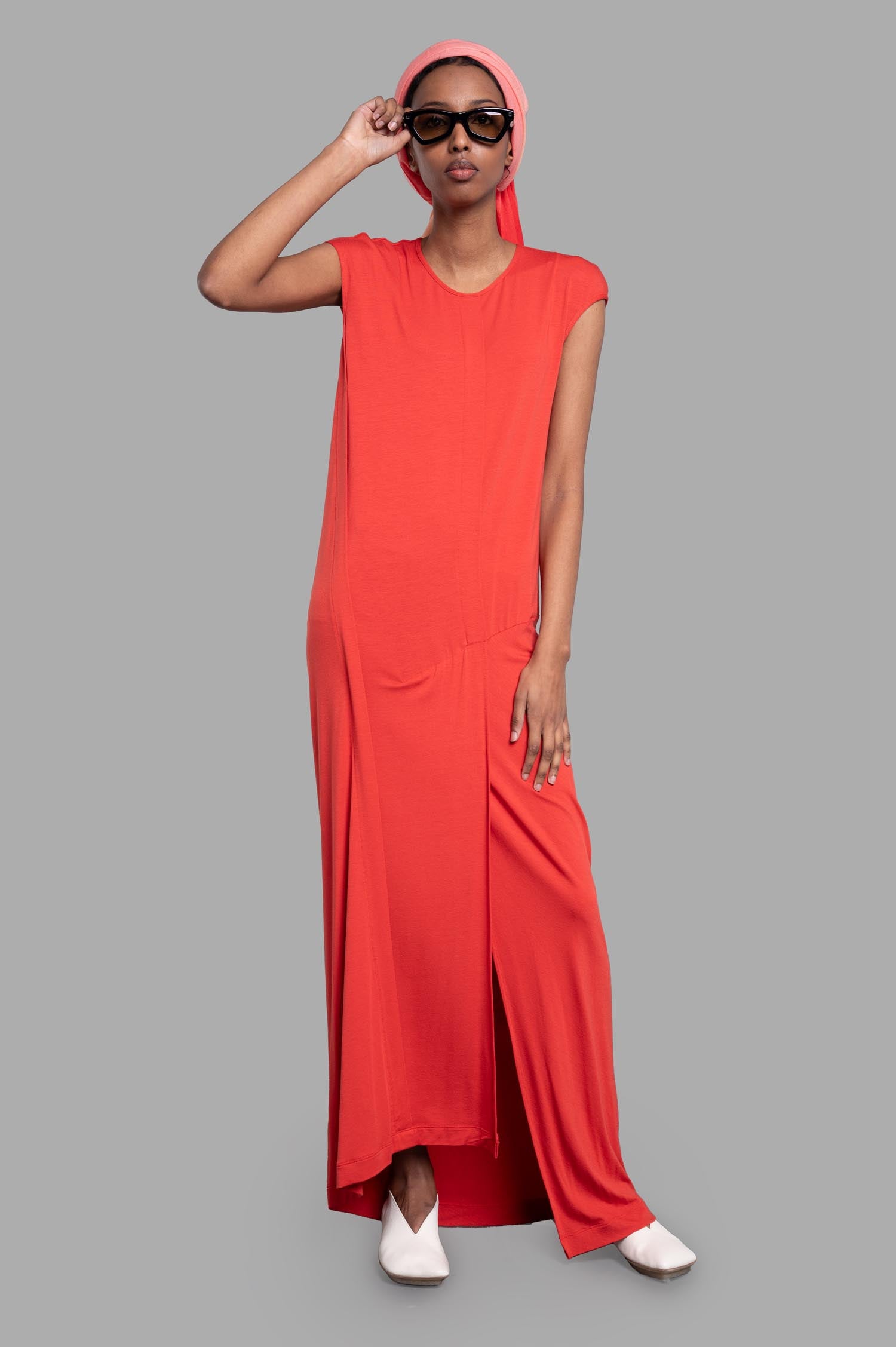 Gentry Portofino paneled column dress on model in coral, showcasing relaxed fit, cap sleeves, and elegant crewneck design.