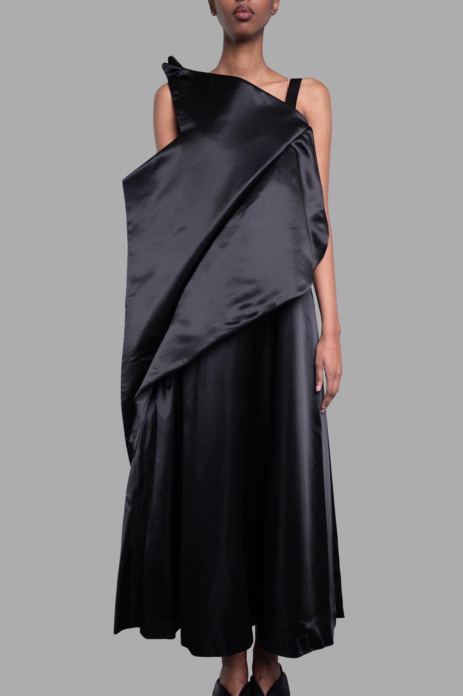 Noir Kei Ninomiya Asymmetric Dress in Black, featuring a draped design shown on a model from the front.