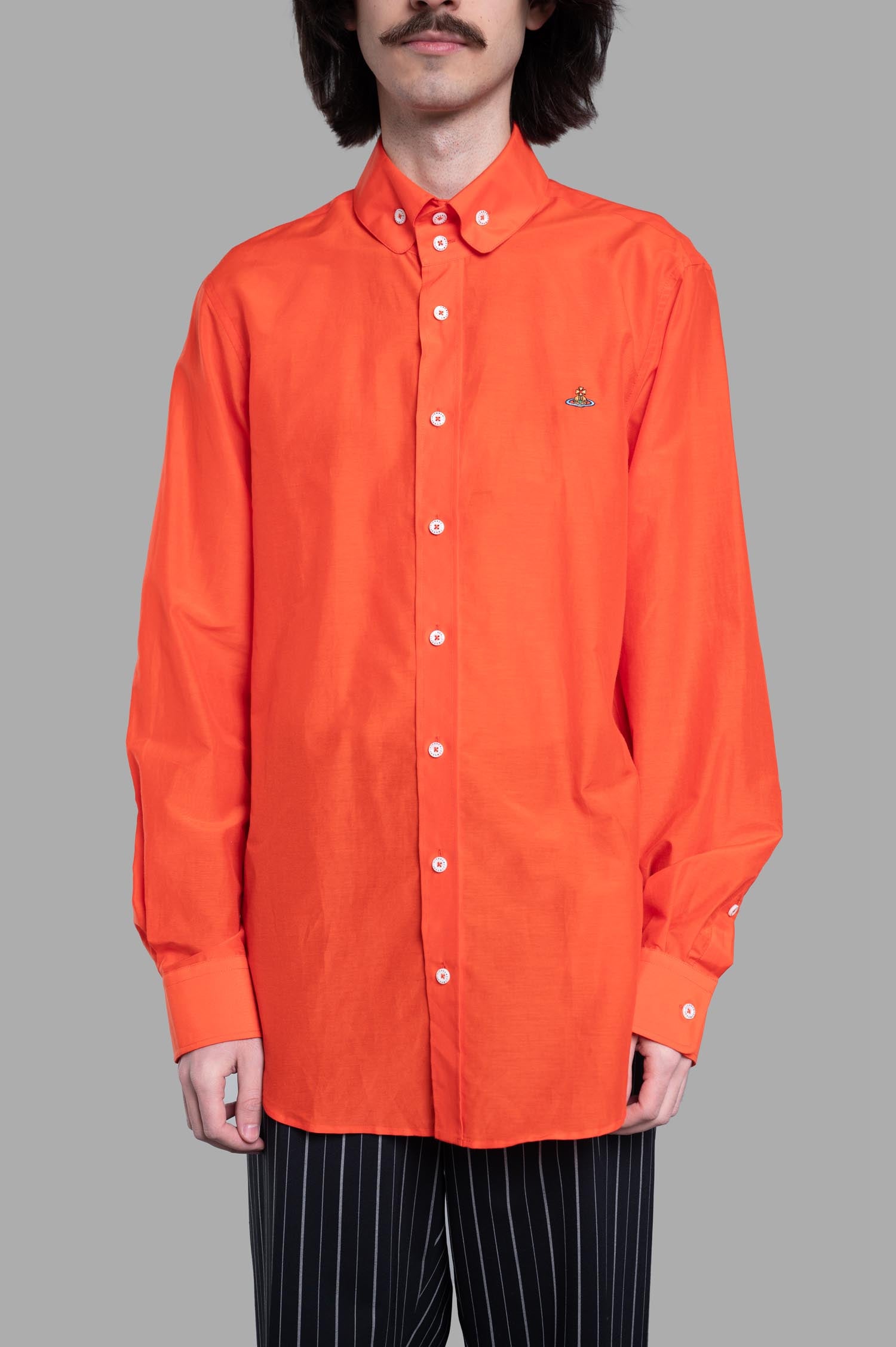 Vivienne Westwood Two-Button Krall Shirt showcased from the side, the bold orange fabric highlights the signature orb detail.
