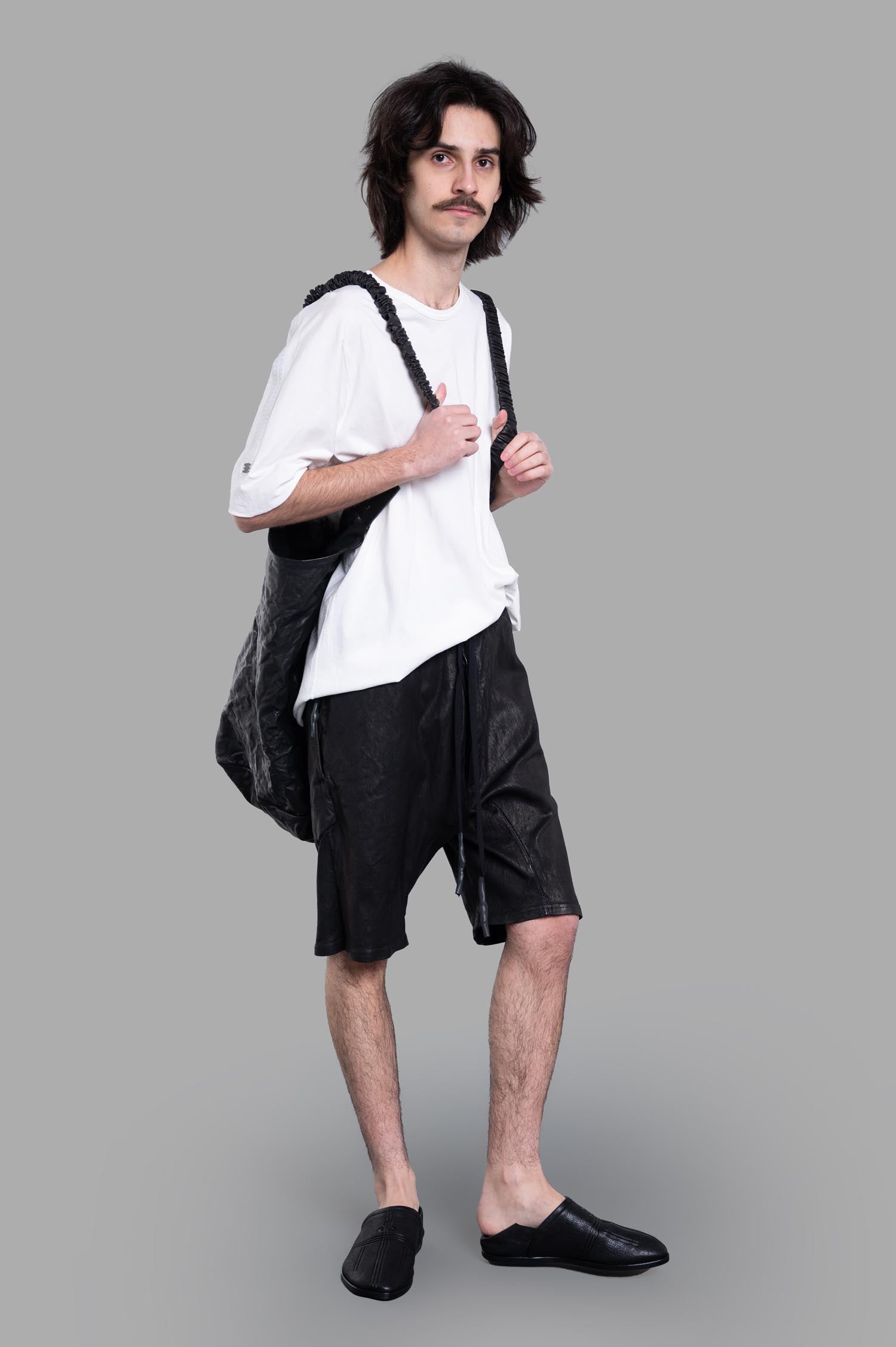 Isaac Sellam Leather Shorts in black on model, showing front design with drawstring waist and side pockets.