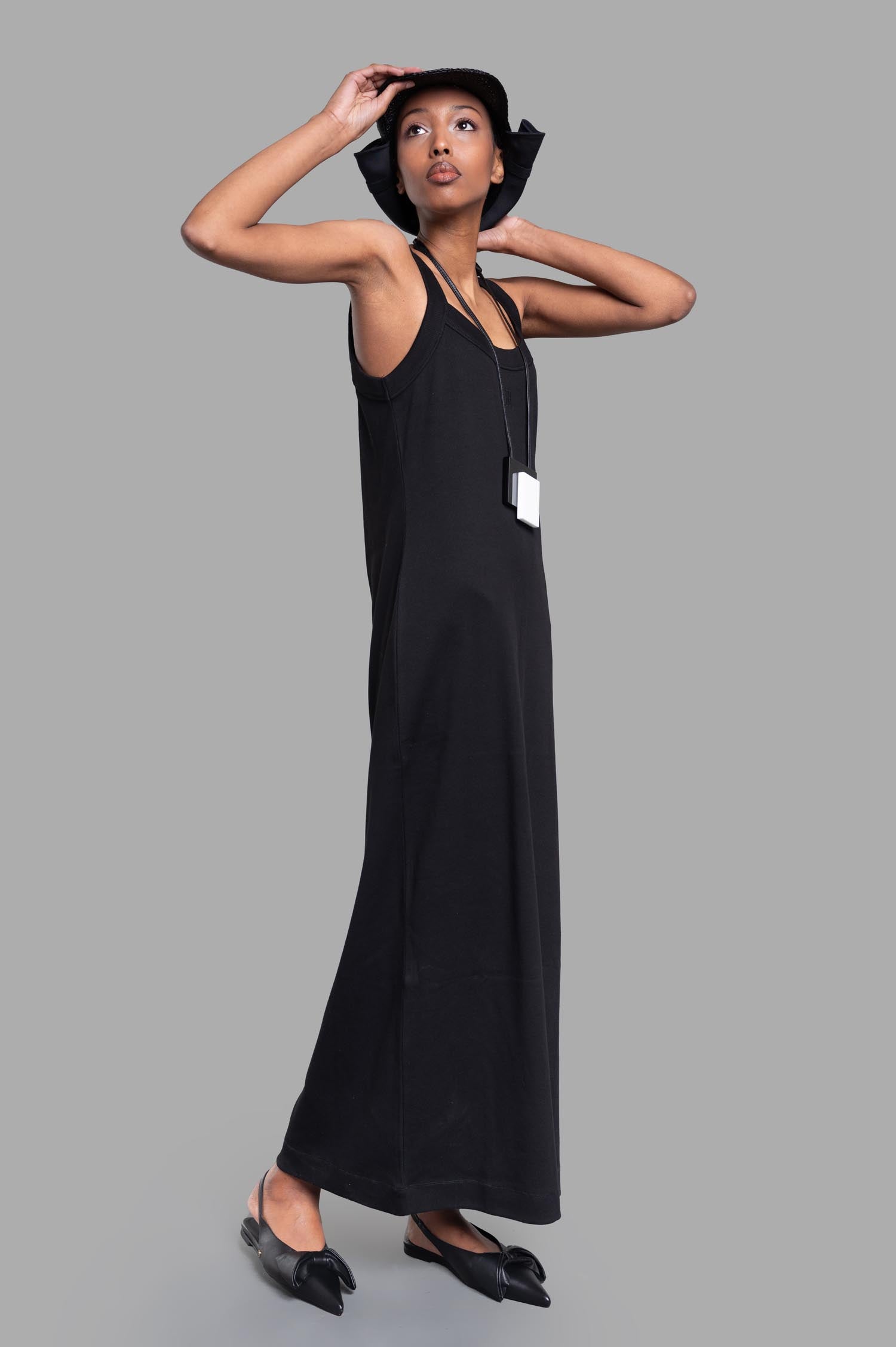 By Malene Birger Lio Maxi Dress in black, side view on model. Features wide straps, low round neckline, elegant silhouette.