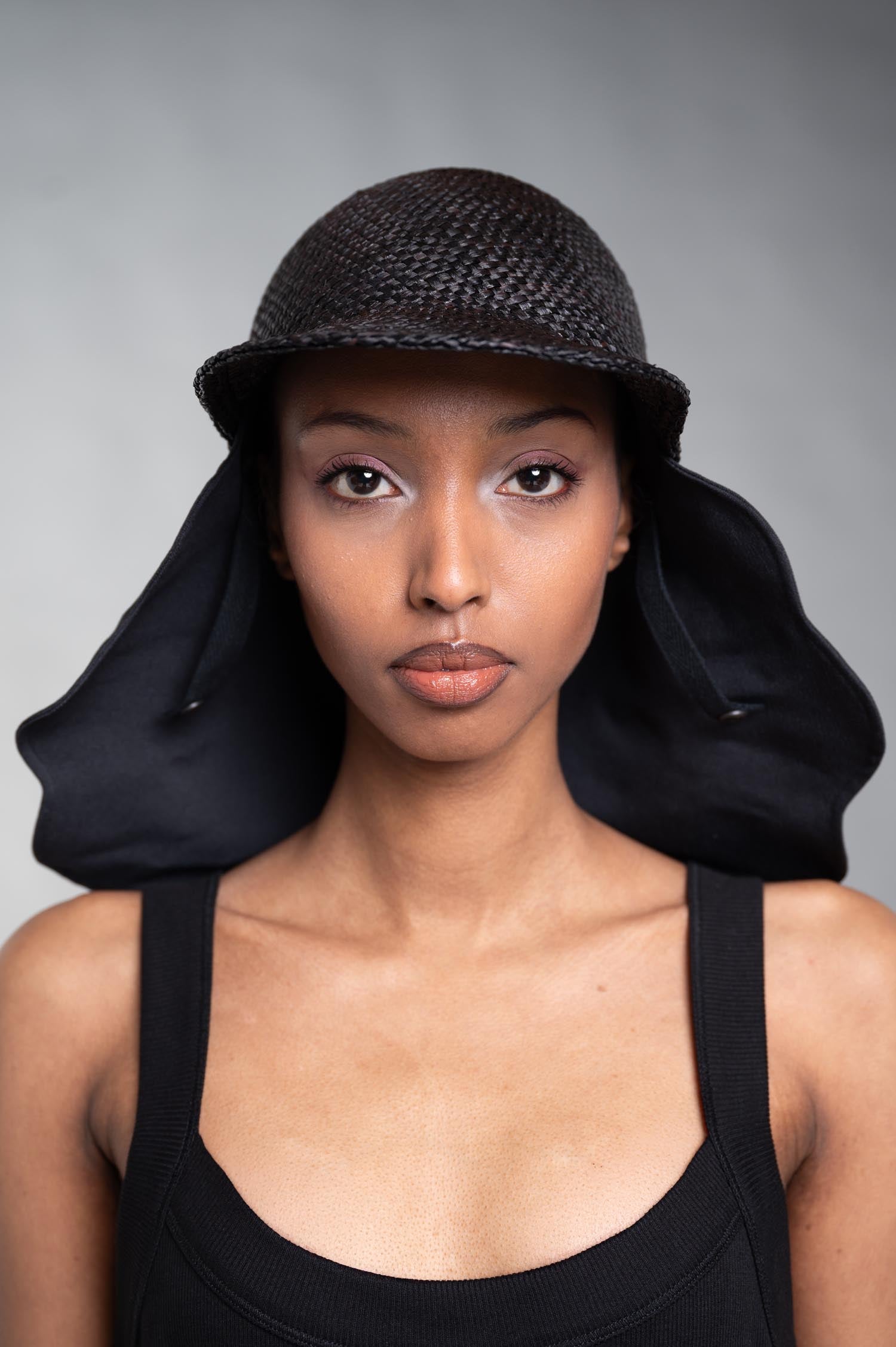 Kijima Takayuki Straw Sun Hat displayed on model, showcasing the elegant black raffia design and protective fabric drape.