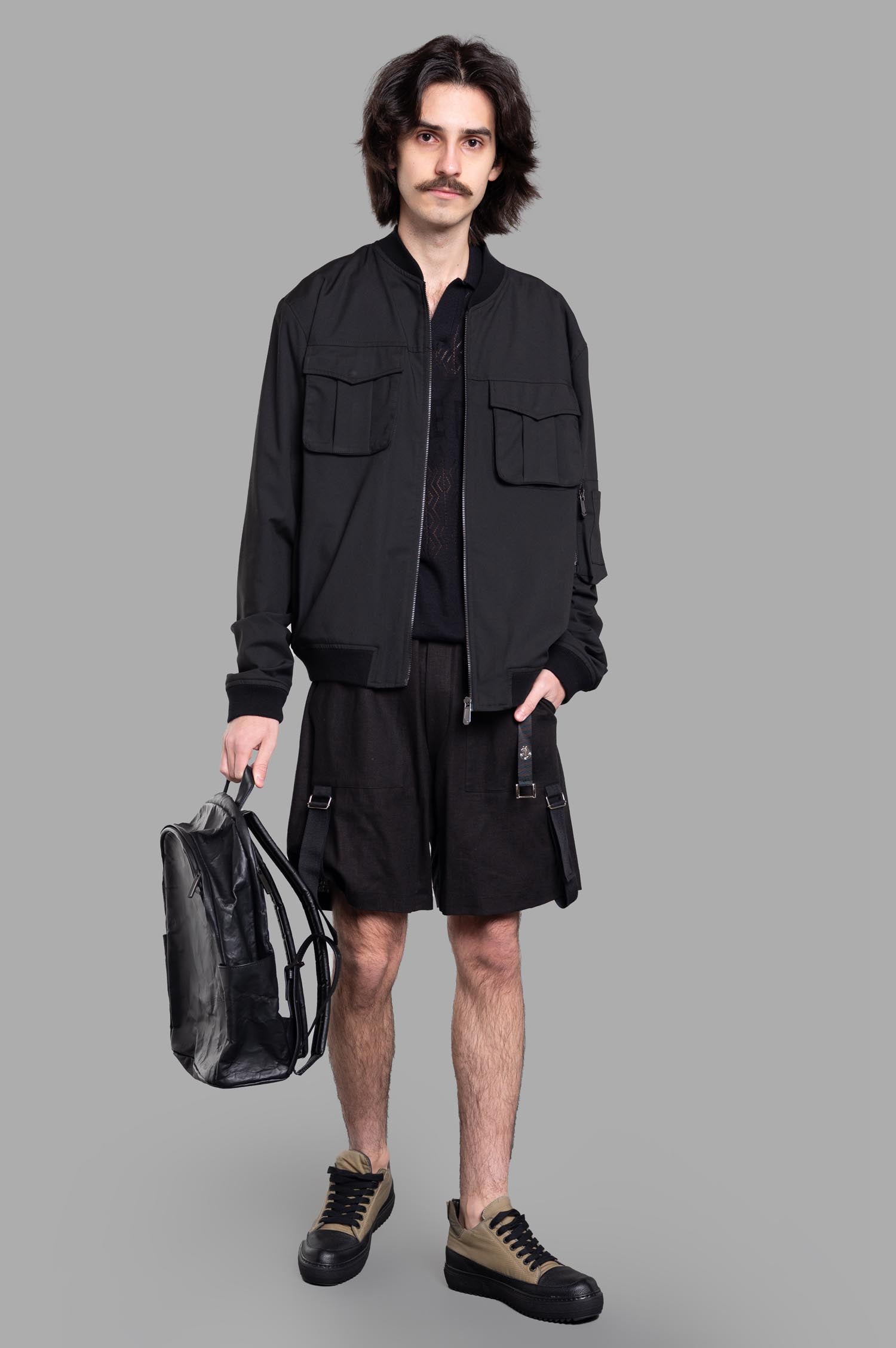 Gaëlle Paris Cargo Jacket front view on-model, paired with shorts and sneakers, holding a black bag.