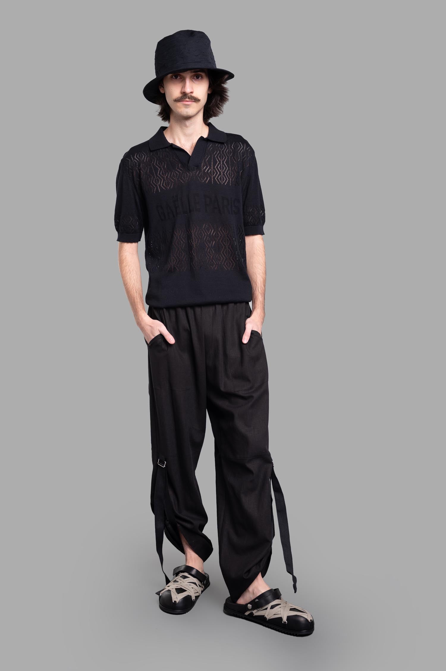 Gaëlle Paris black knit polo shirt with logo, classic collar, worn by model; front view displaying texture and fit.