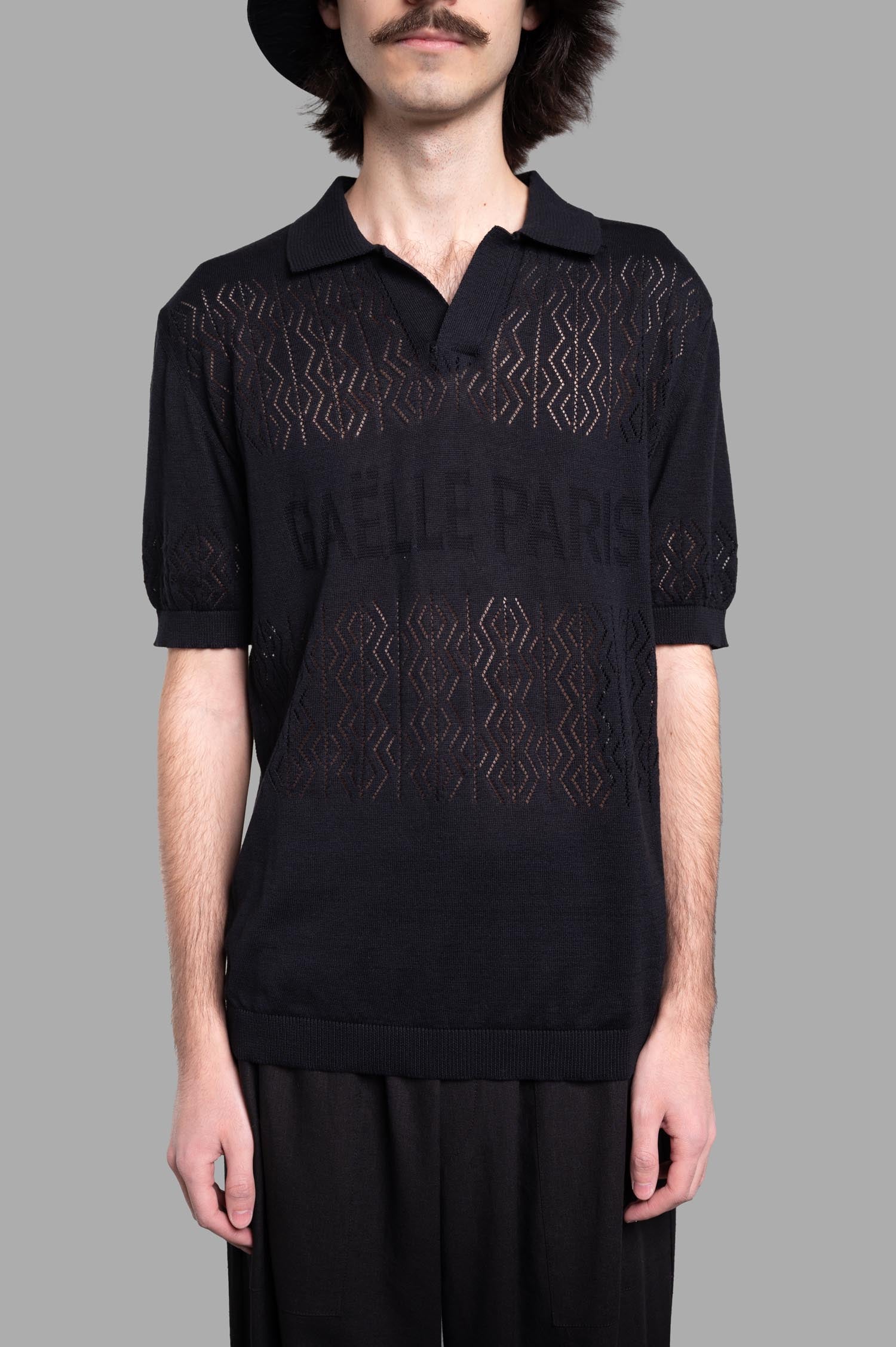 Gaëlle Paris Knit Polo Shirt in black, featuring a classic collar and logo, showcased on a model with a textured design.