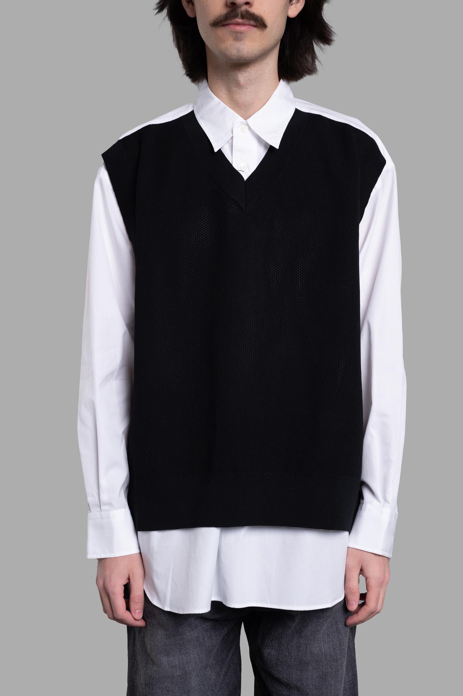 Comme des Garçons Layered Shirt featuring a built-in black vest on a model, showcasing a stylish black and white combination.