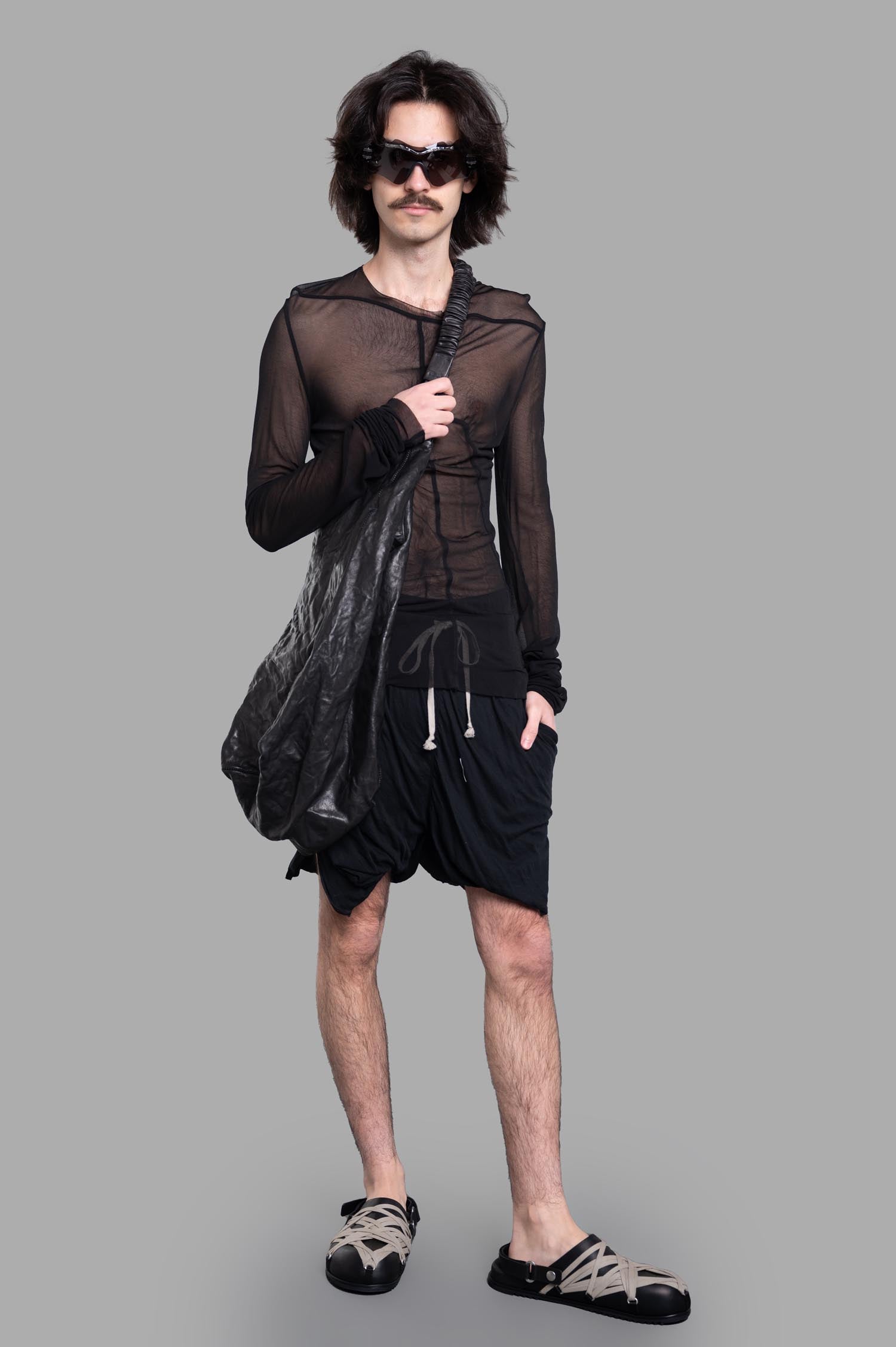 Rick Owens Draped Shorts in black on-model front view, featuring elastic waistband and drawstring for casual style.