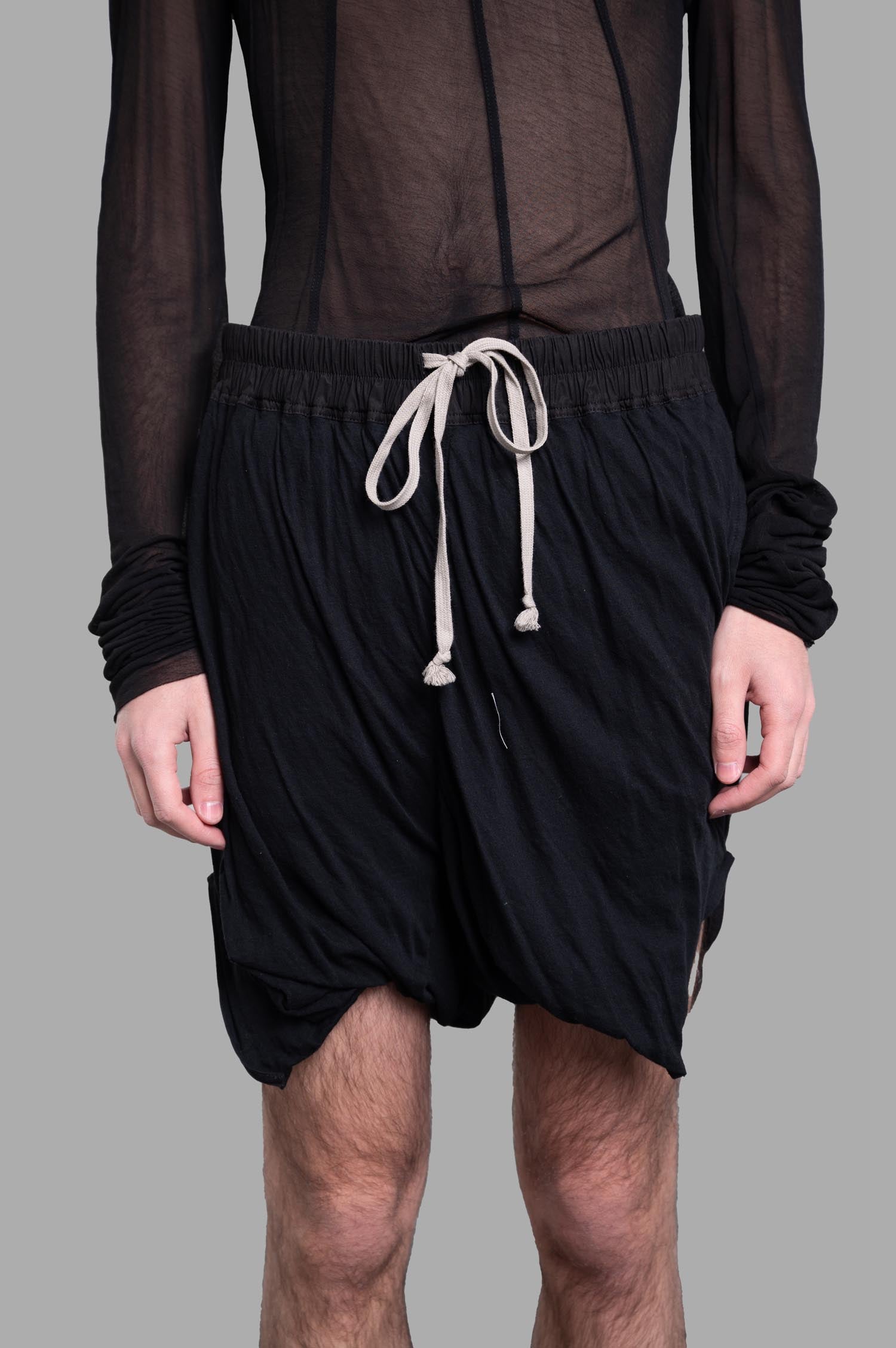 Rick Owens Draped Shorts with elasticated waistband, showcasing lightweight black fabric and relaxed fit on model.