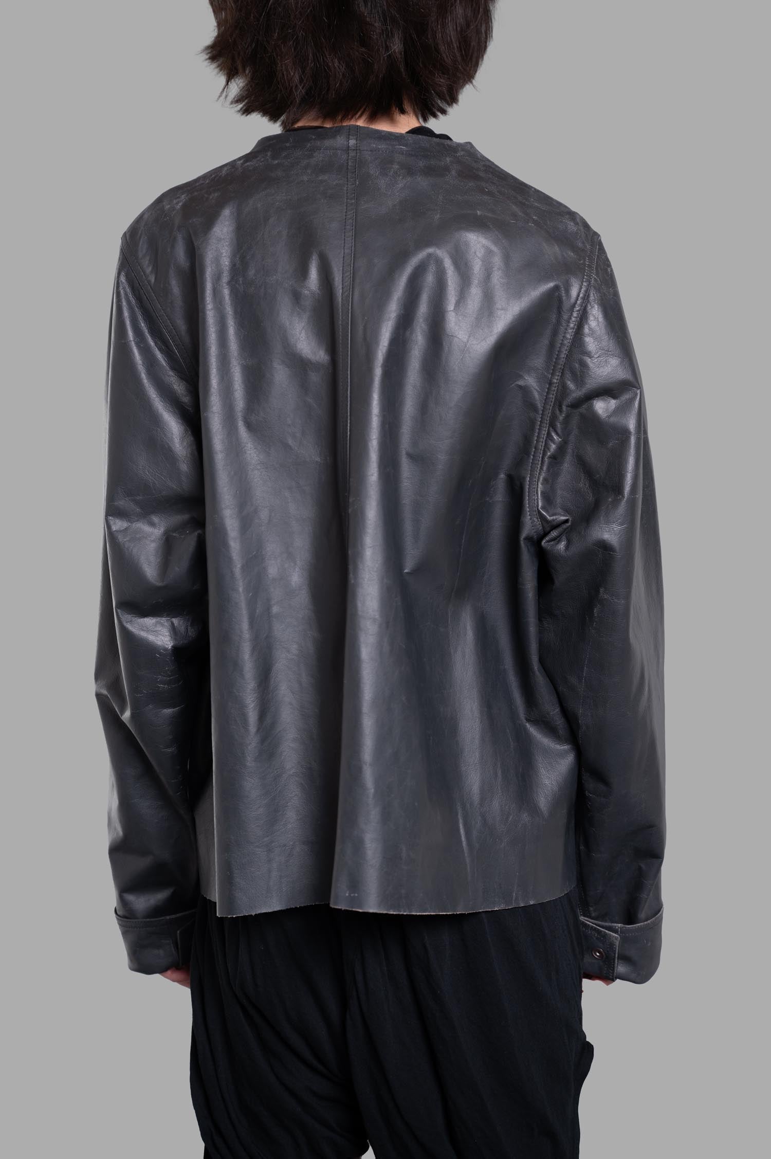 Rick Owens Hollywood V-safety Jacket shown from the back, featuring a boxy shape in sleek black leather with concealed cuffs.