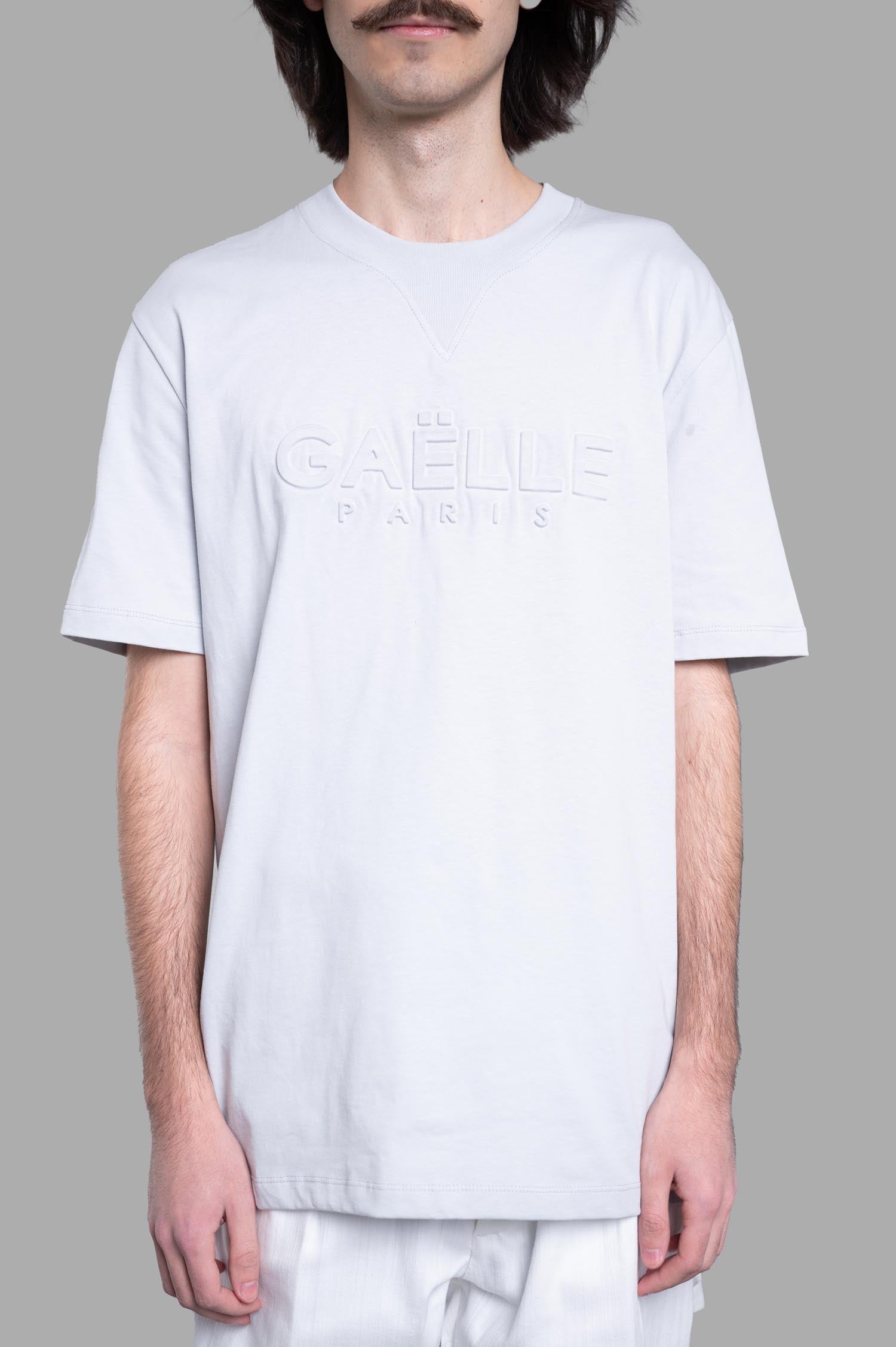 Gaëlle Paris Logo T-shirt in grey featuring a front logo, relaxed fit, rounded collar, and short sleeves, shown on model.