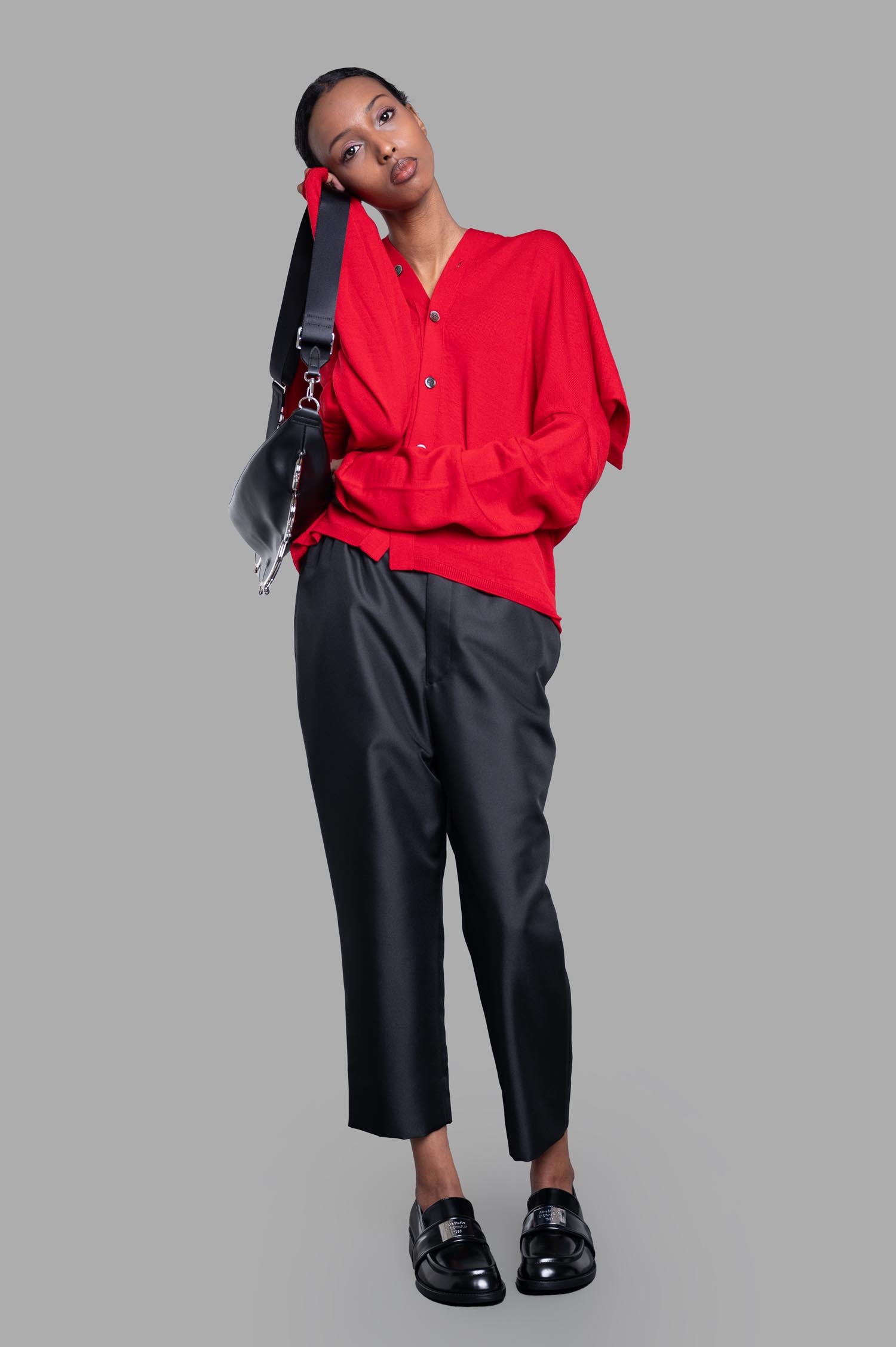 Comme des Garçons Oversized Fine-knit Cardigan in red, buttoned front view on model, showcasing cozy wool texture.