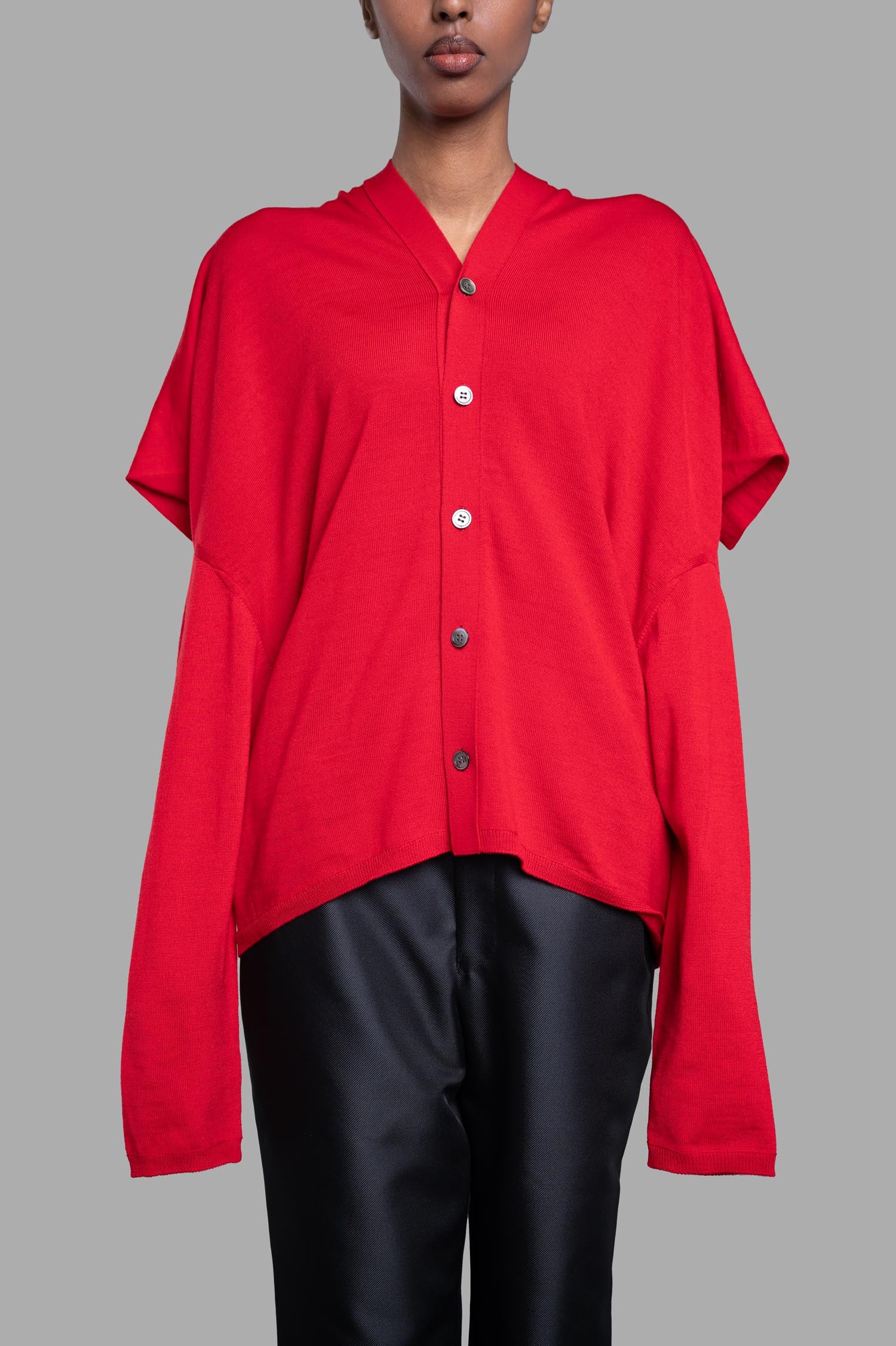 Comme des Garçons Oversized Fine-knit Cardigan in red, featuring a V-shaped neck and button closure, displayed on model.