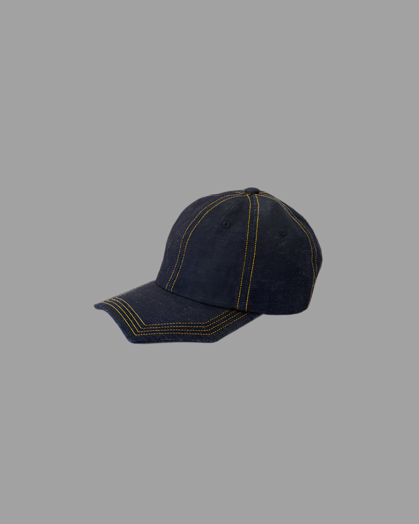 Kijima Takayuki Asymmetric Denim Cap, side view showcasing yellow stitching on blue denim fabric.