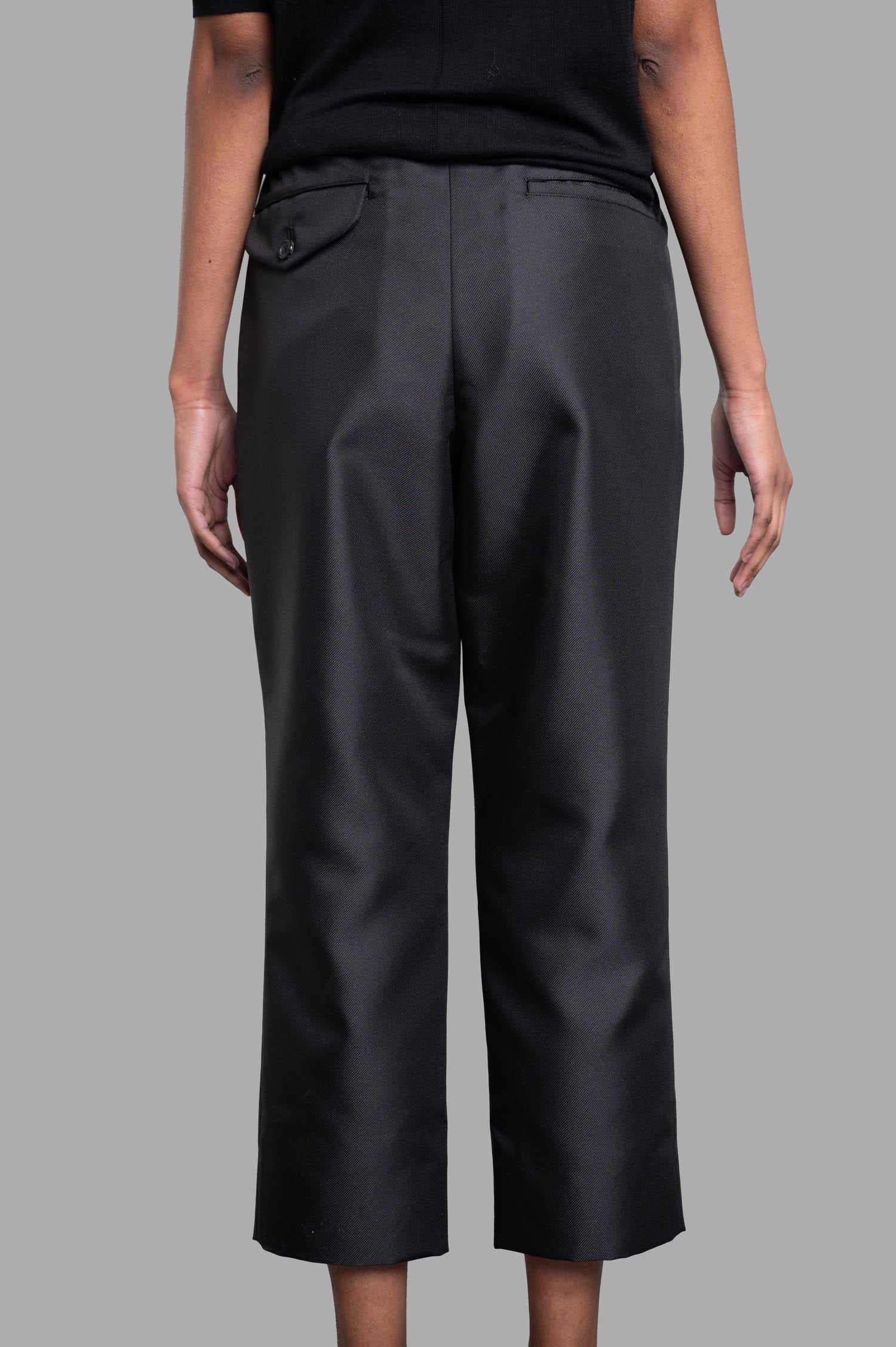 Comme des Garçons Cropped Trousers in black, showcasing sleek straight legs and a comfortable elasticized waistband.