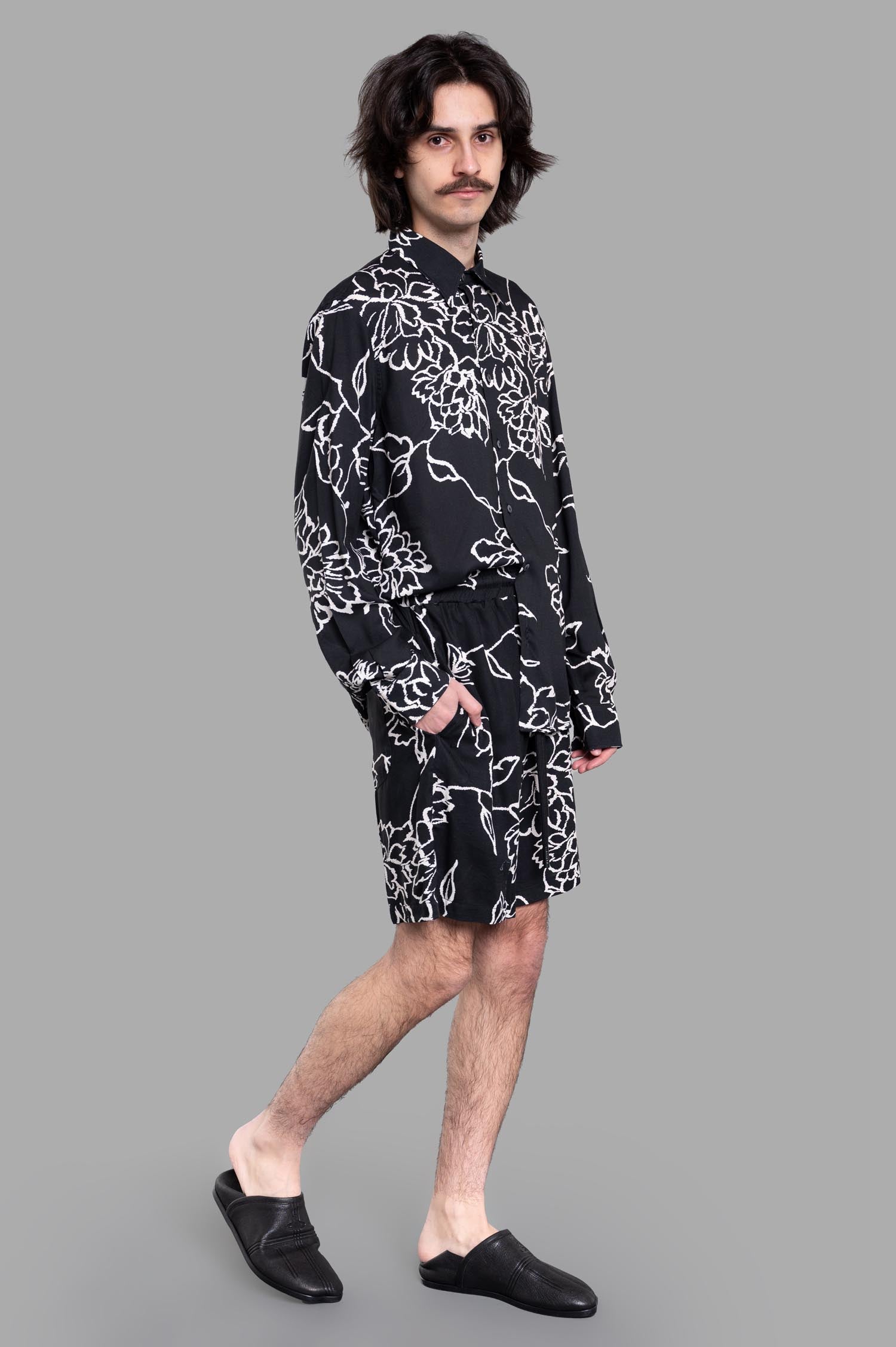 Gaëlle Paris Floral Shorts on model, black Bermuda style with elastic waistband and floral design, paired with matching shirt.