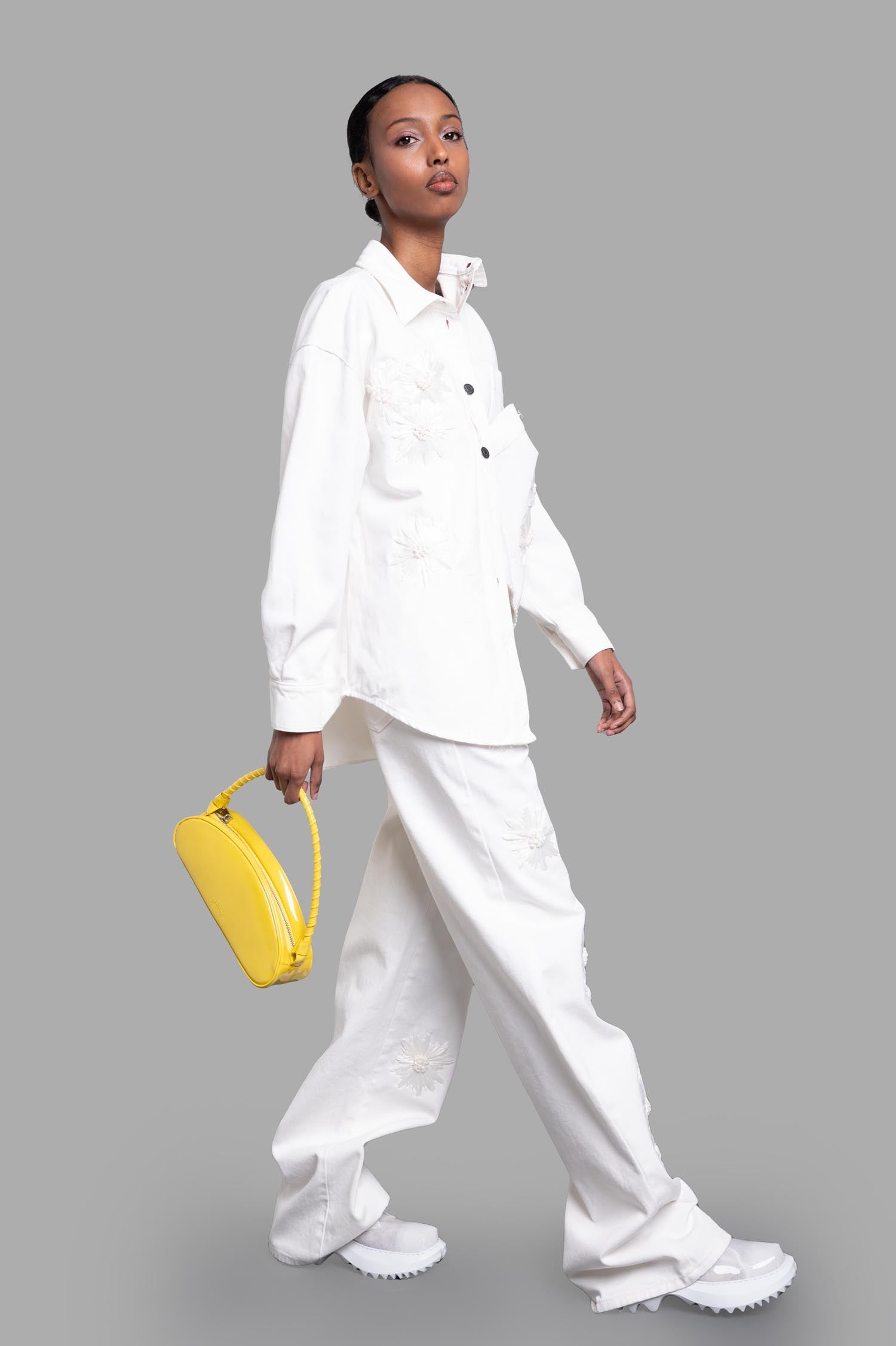 MSGM Denim Shirt with Raffia Flowers, front view on model, white with embroidered details, styled with yellow bag.