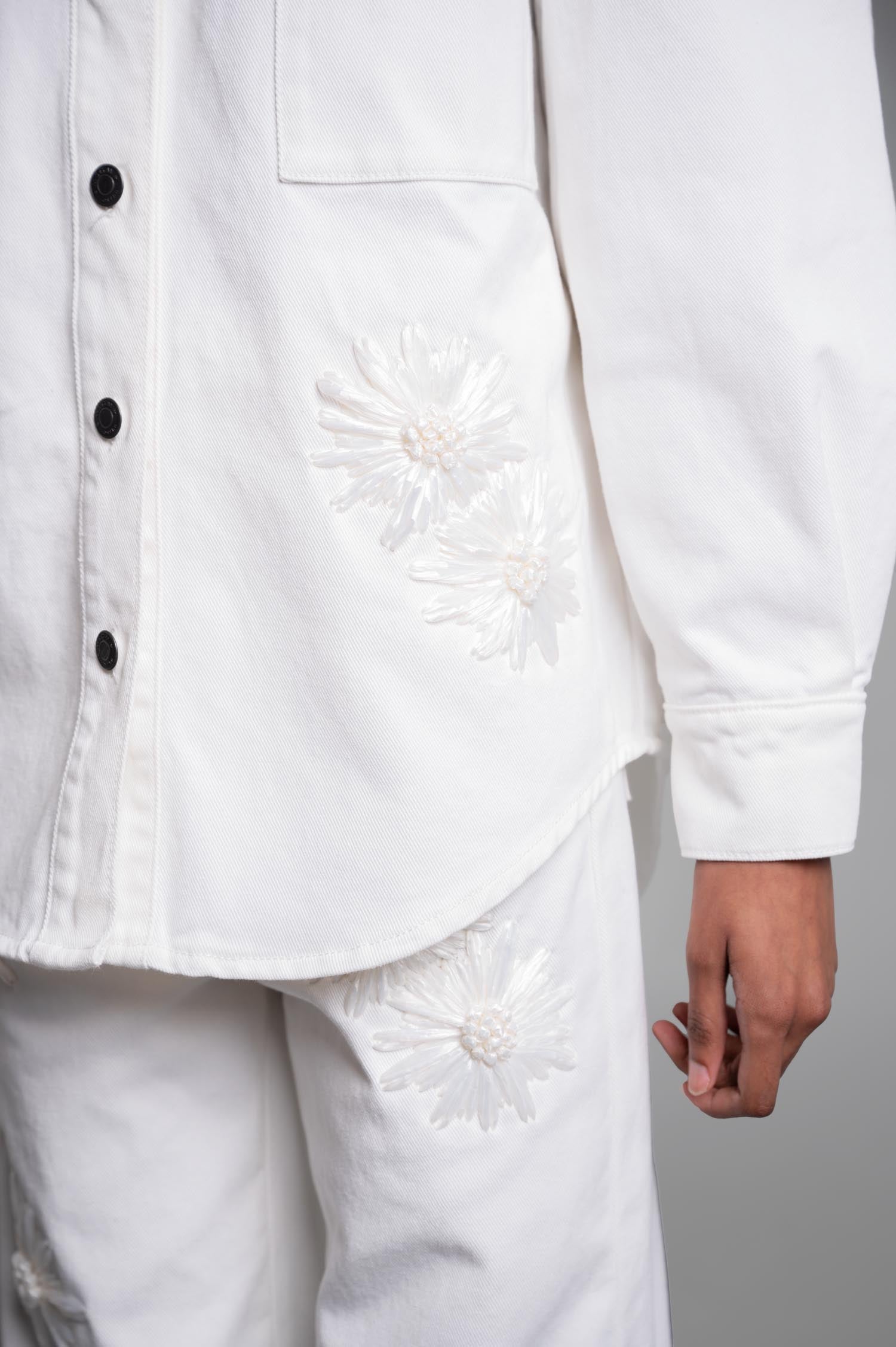 **MSGM Denim Shirt with Raffia Flowers featuring delicate embroidery and a classic collar, displayed with cuff detail and patch pocket.**