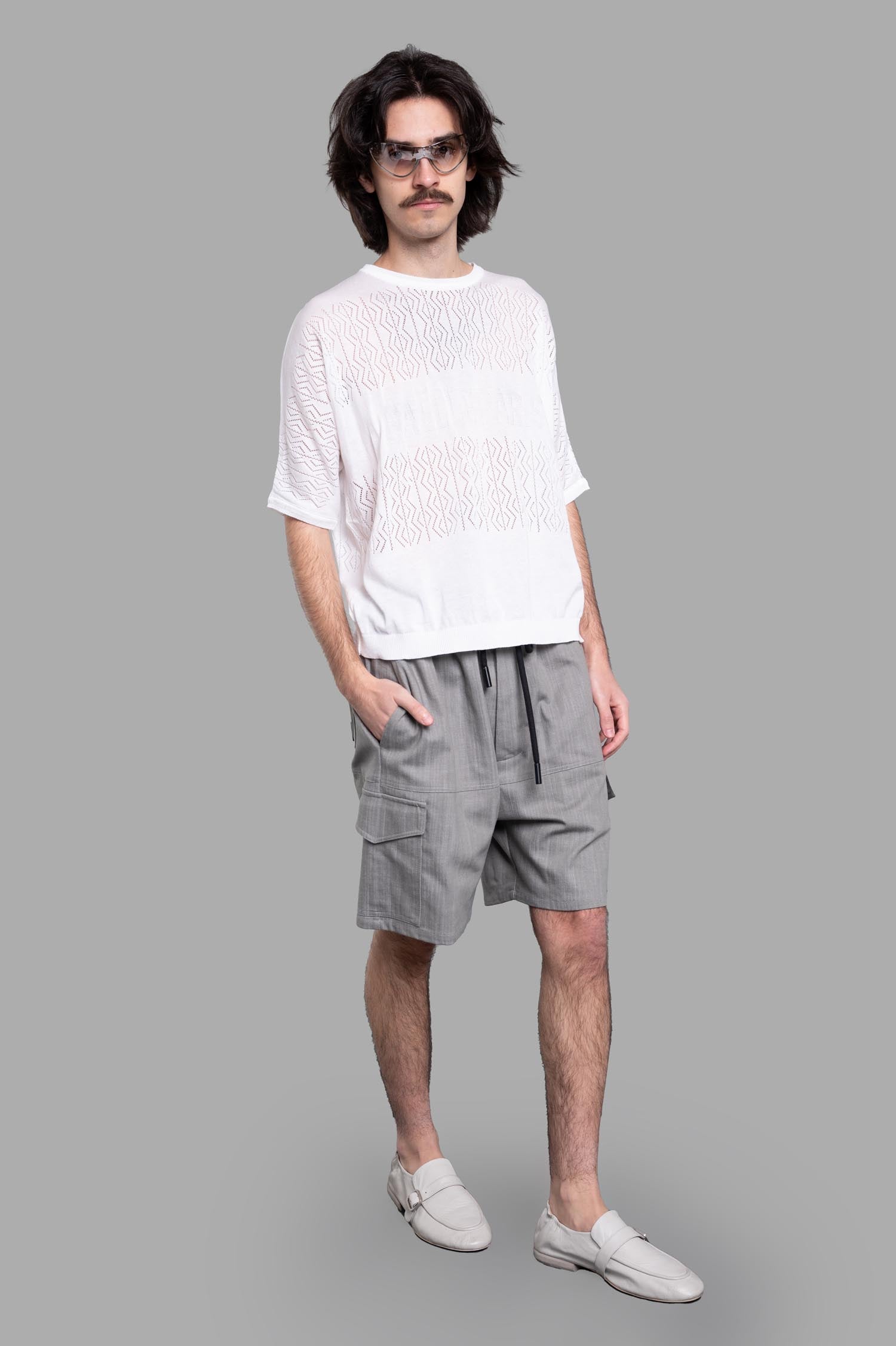 Gaëlle Paris Drawstring Bermudas in Grey worn by a model, featuring cargo-style design with front and side pockets.