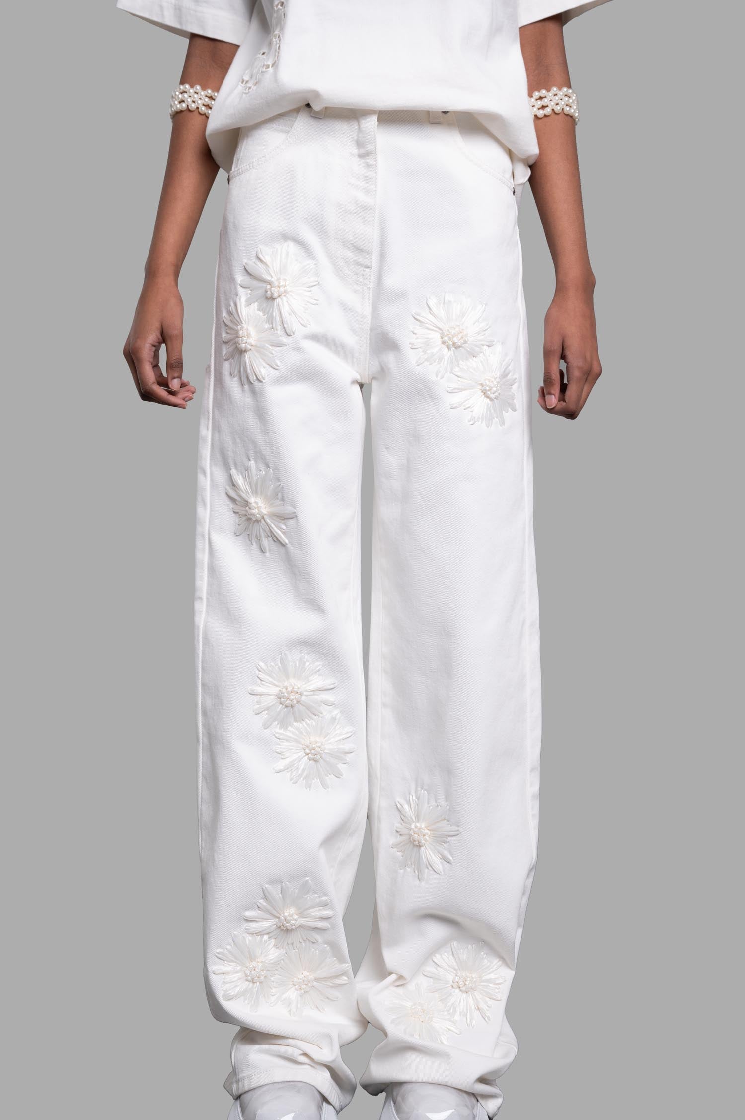 **Alt Text:** MSGM Denim Trousers with Raffia Flowers, featuring embroidered floral details and a relaxed fit, displayed on model.