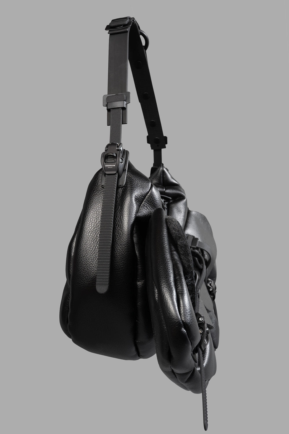 Innerraum Small Half Moon Bag with Pockets showing adjustable technical strap and soft, padded matte black texture.