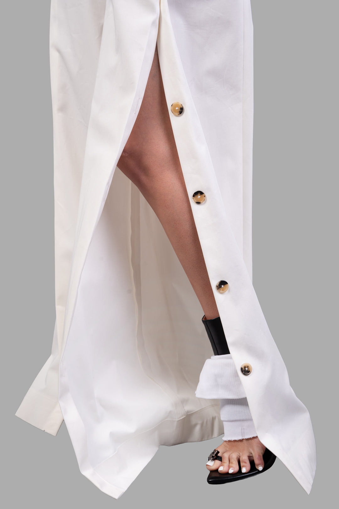 A.W.A.K.E. MODE Split Cotton-poplin Trousers showcasing button-fastening splits and pleated waist, styled with heels.