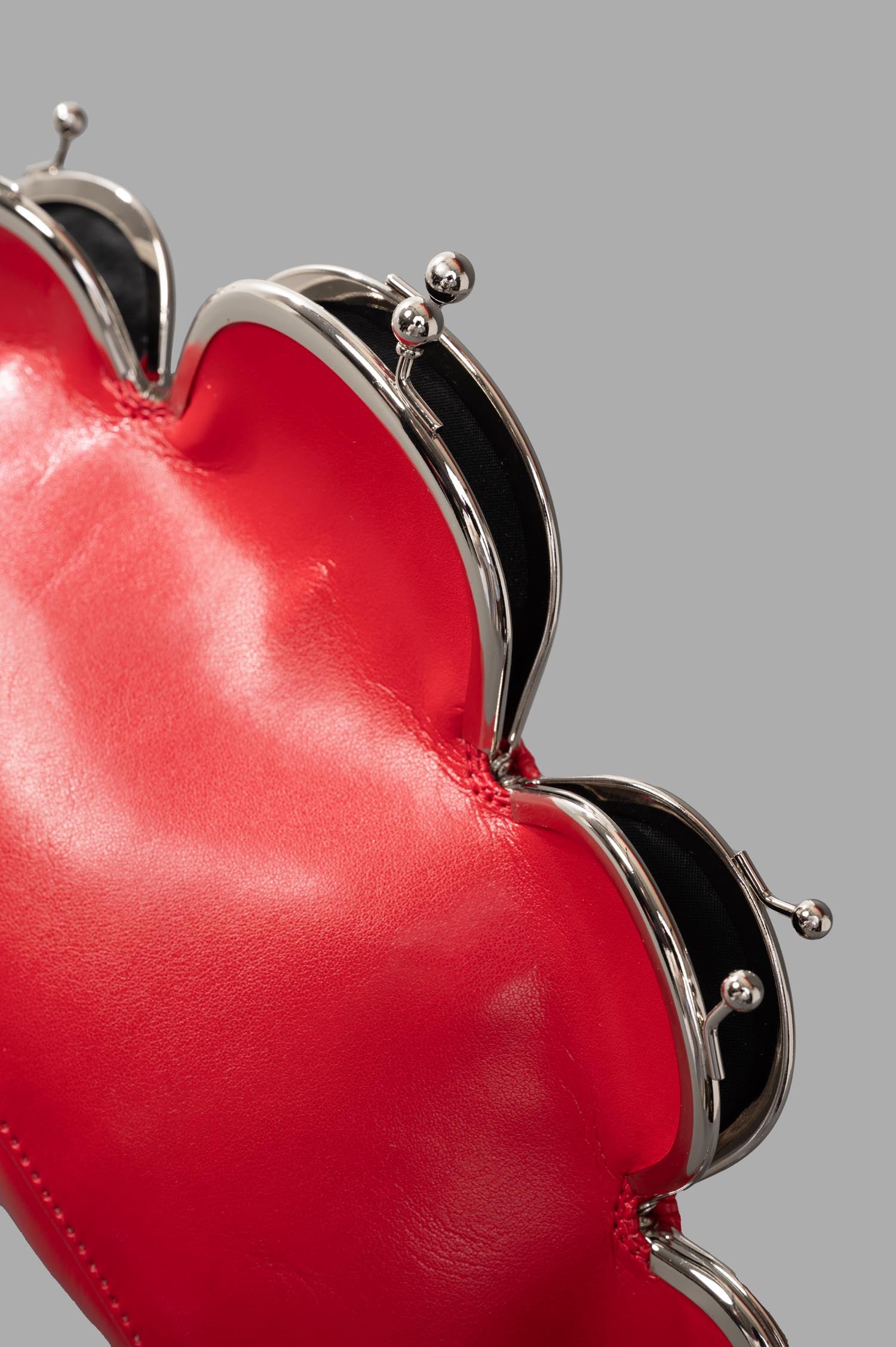 Noir Kei Ninomiya Kiss-Lock Cross Body Bag close-up showing shiny red exterior and detailed kiss clasp features.