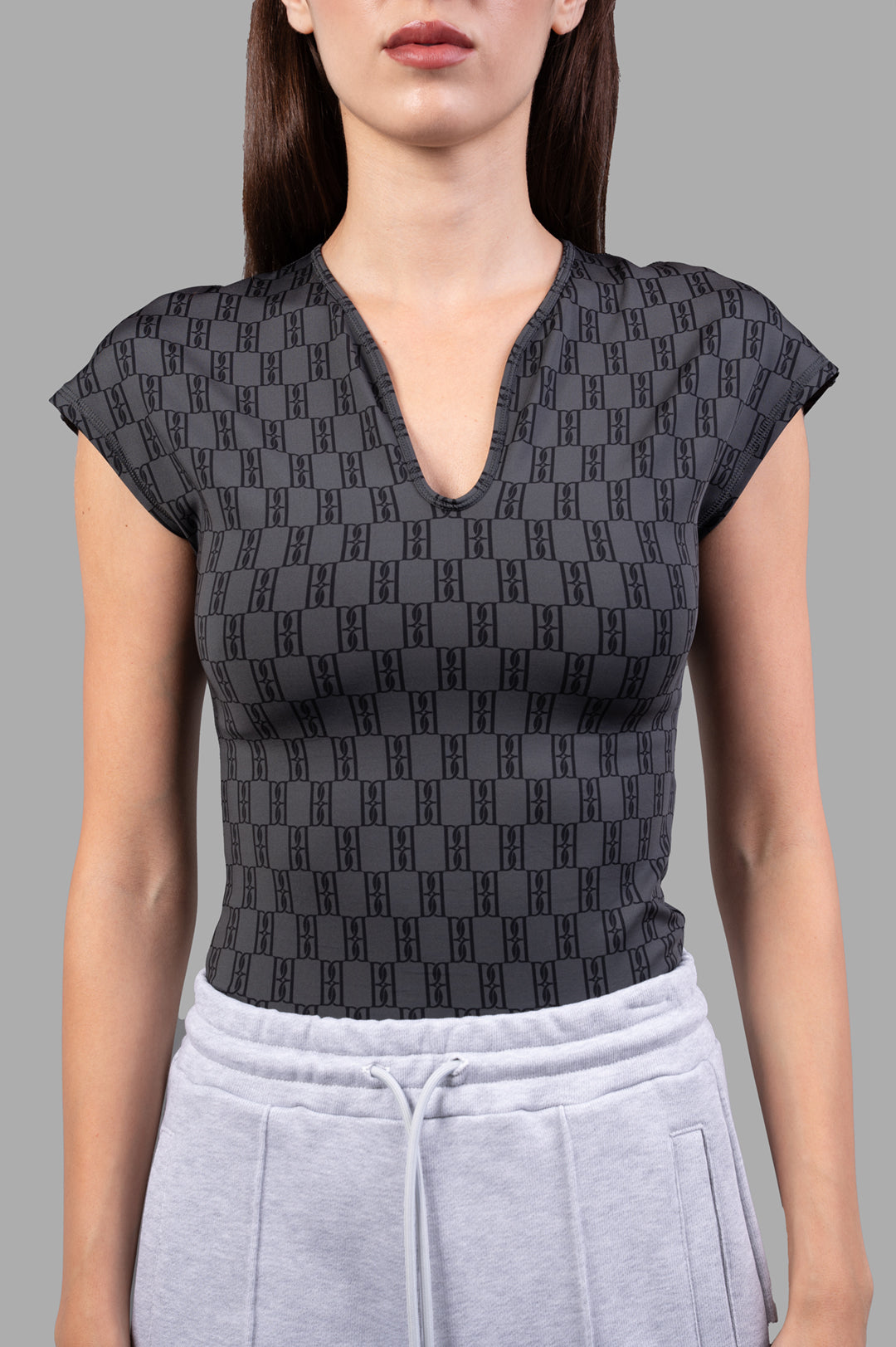 By Malene Birger Venazia Athletic Top in black & grey, featuring a V-neck and body-hugging fit, shown on model.