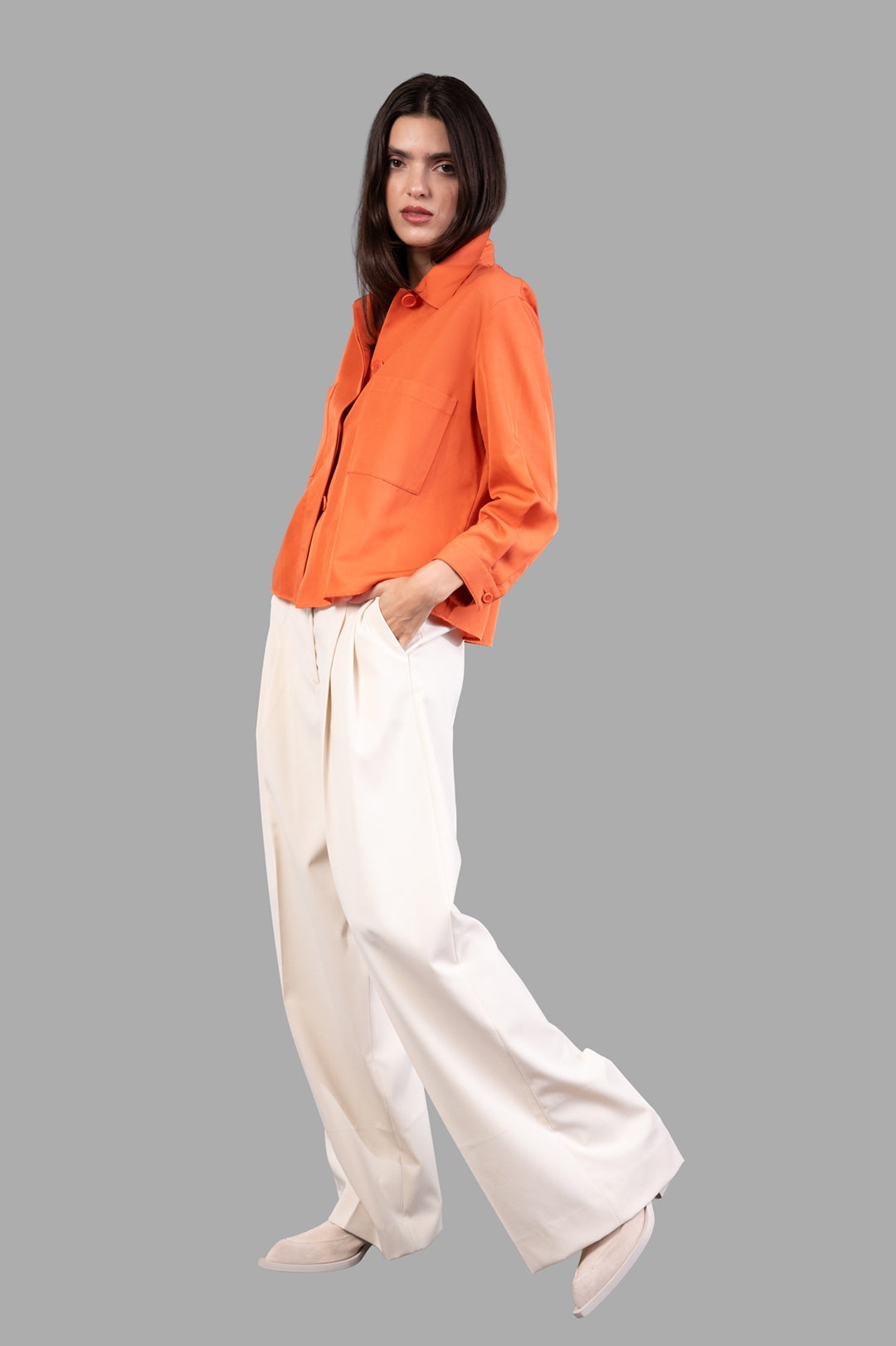 By Malene Birger Cymbaria High-waist Trousers in pearl color, front view on model, showcasing wide-leg and pleated design.