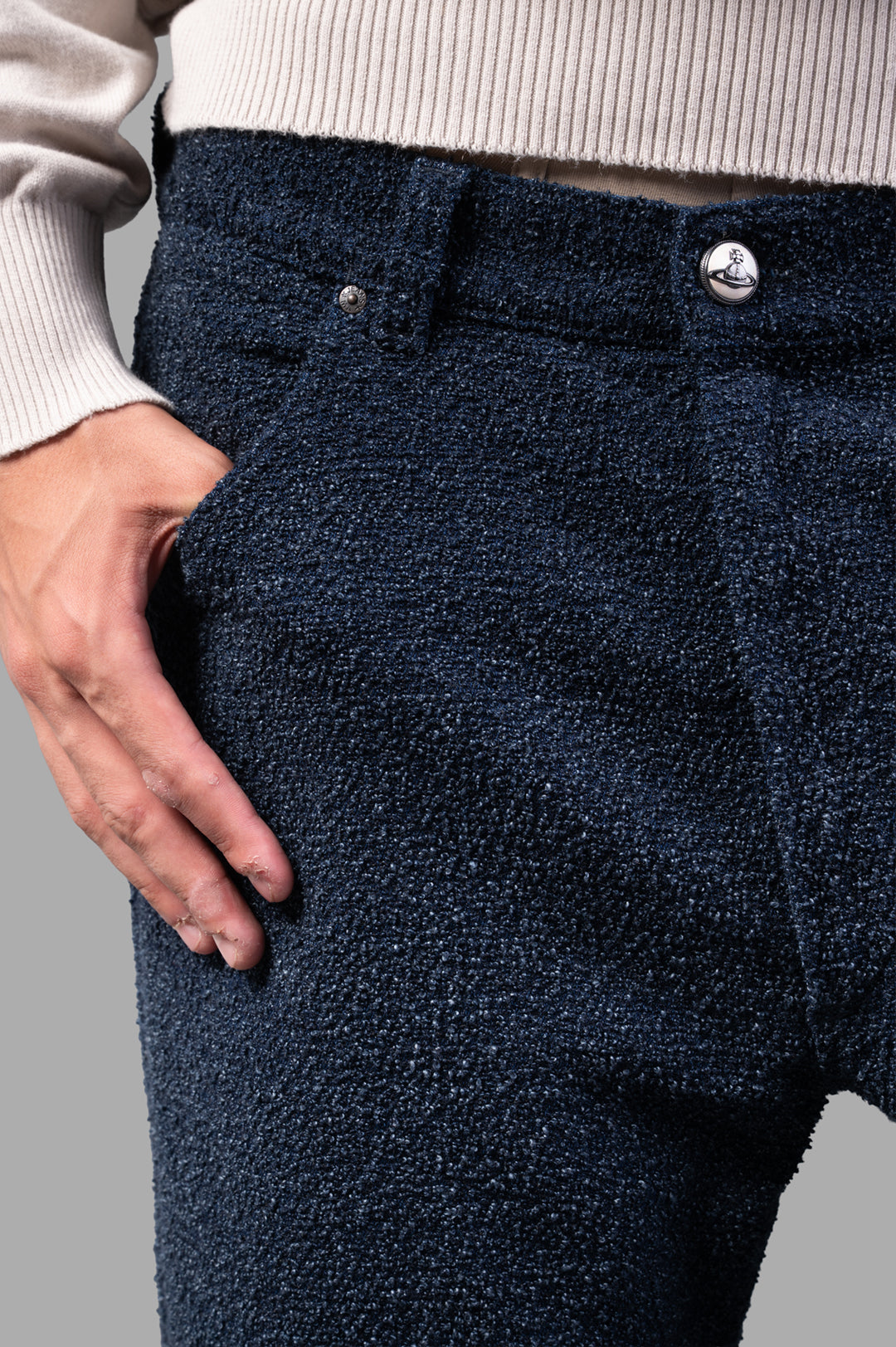 Vivienne Westwood Ranch Bouclé Wool Jeans close-up of textured fabric and branded top button, styled with a sweater.