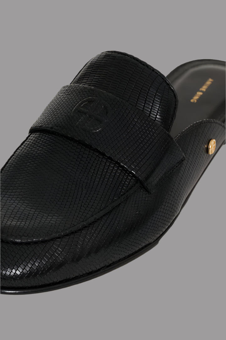Anine Bing Corrine Mules in black leather, featuring faux lizard texture and gold-tone details, close-up view.